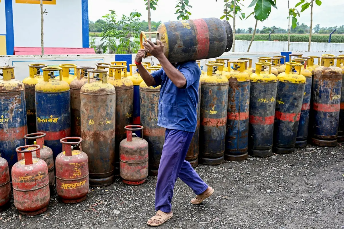 A worker stacks up a commercial LPG cylinder amid the ongoing supply crisis, in Malda, West Bengal.| Photo: PTI