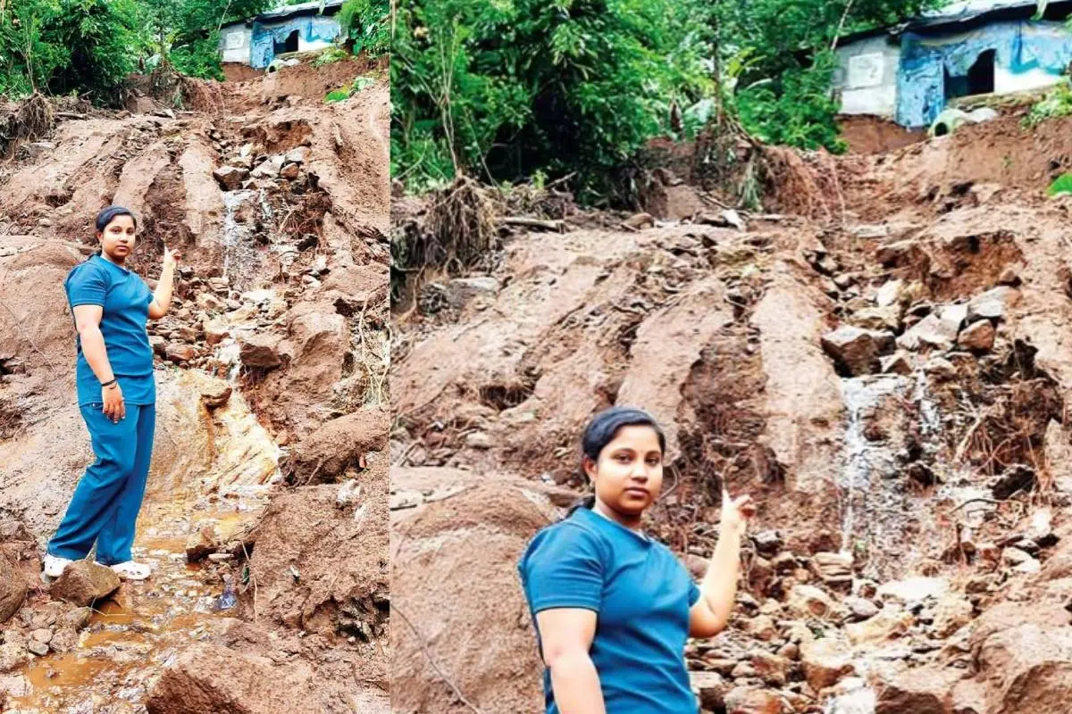 Nithya points towards the landslide trail. Her house can be seen at the top