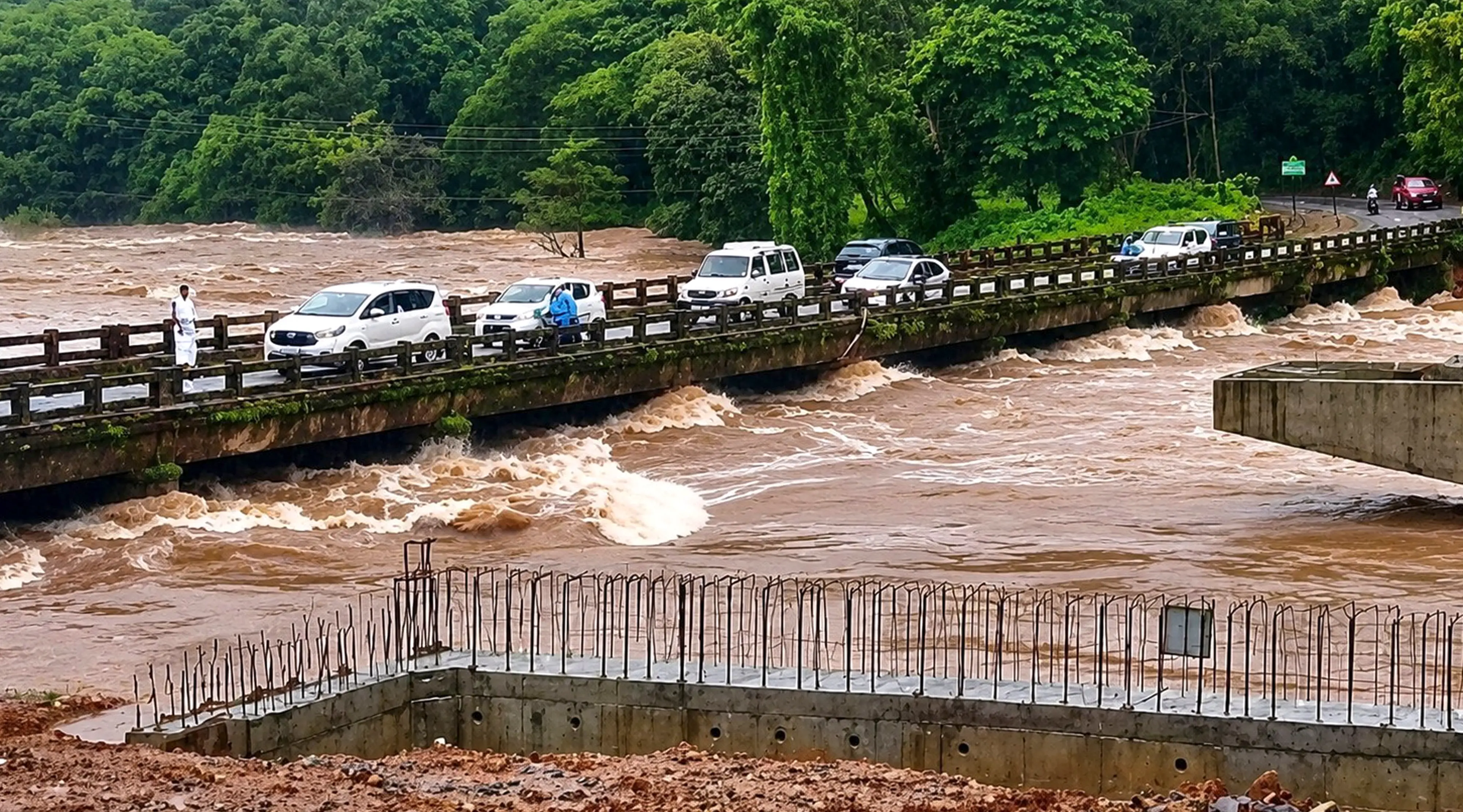 Vehicles move across a bridge as the swollen Netravathi river flows in spite of heavy rainfall | Photo: PTI