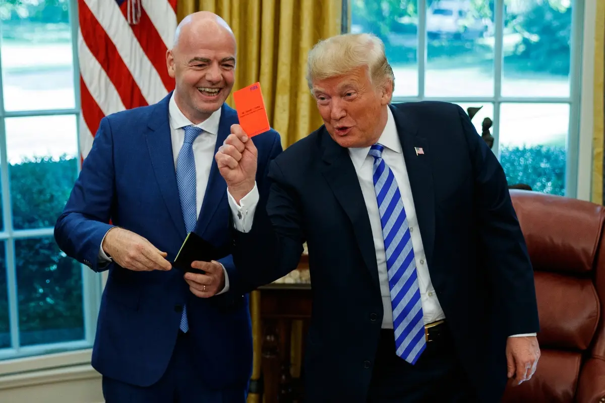 File: US President Donald Trump holds up a red card during a meeting with FIFA president Gianni Infantino in the Oval Office of the White House | Photo: AP