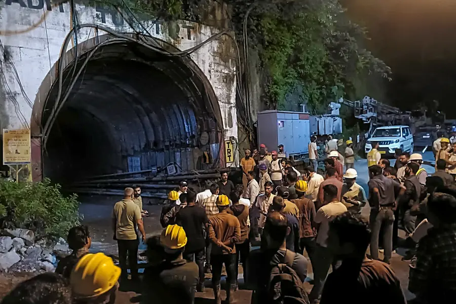 People gather after a landslide in an under-construction tunnel of the Vishnugad-Pipalkoti Hydroelectric Project, in Chamoli district, Uttarakhand