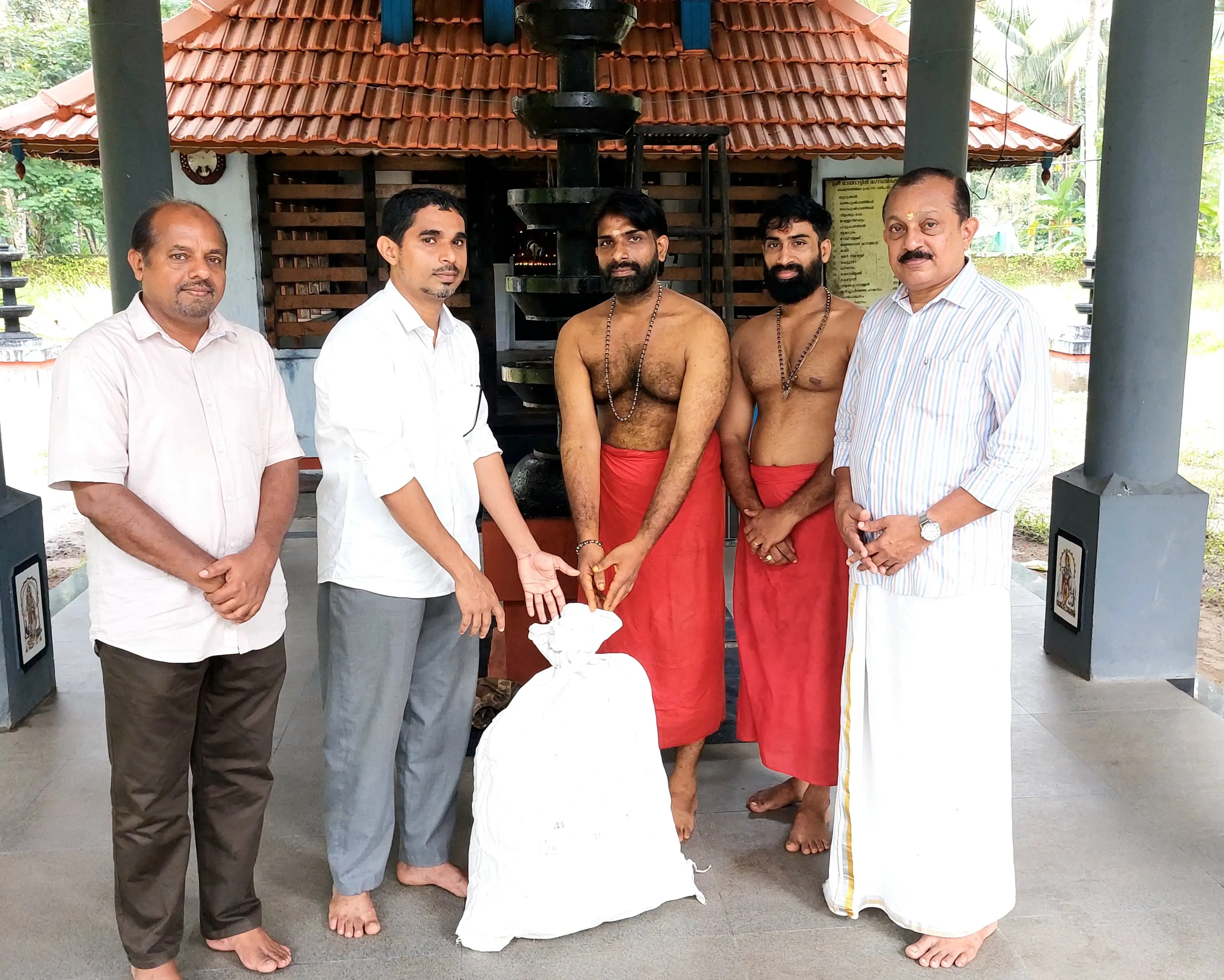 മാങ്ങാട്ടിരി ഭഗവതി കോട്ടയിൽ നിറപുത്തരിക്കുള്ള നെല്ല് ക്ഷേത്രം പൂജാരി ഇടത്തോട്ടിൽ മഹേഷ് ആവേന് അധ്യാപകനായ സൽമാൻ ക്ഷേത്രനടയിലെത്തി കൈമാറുന്നു