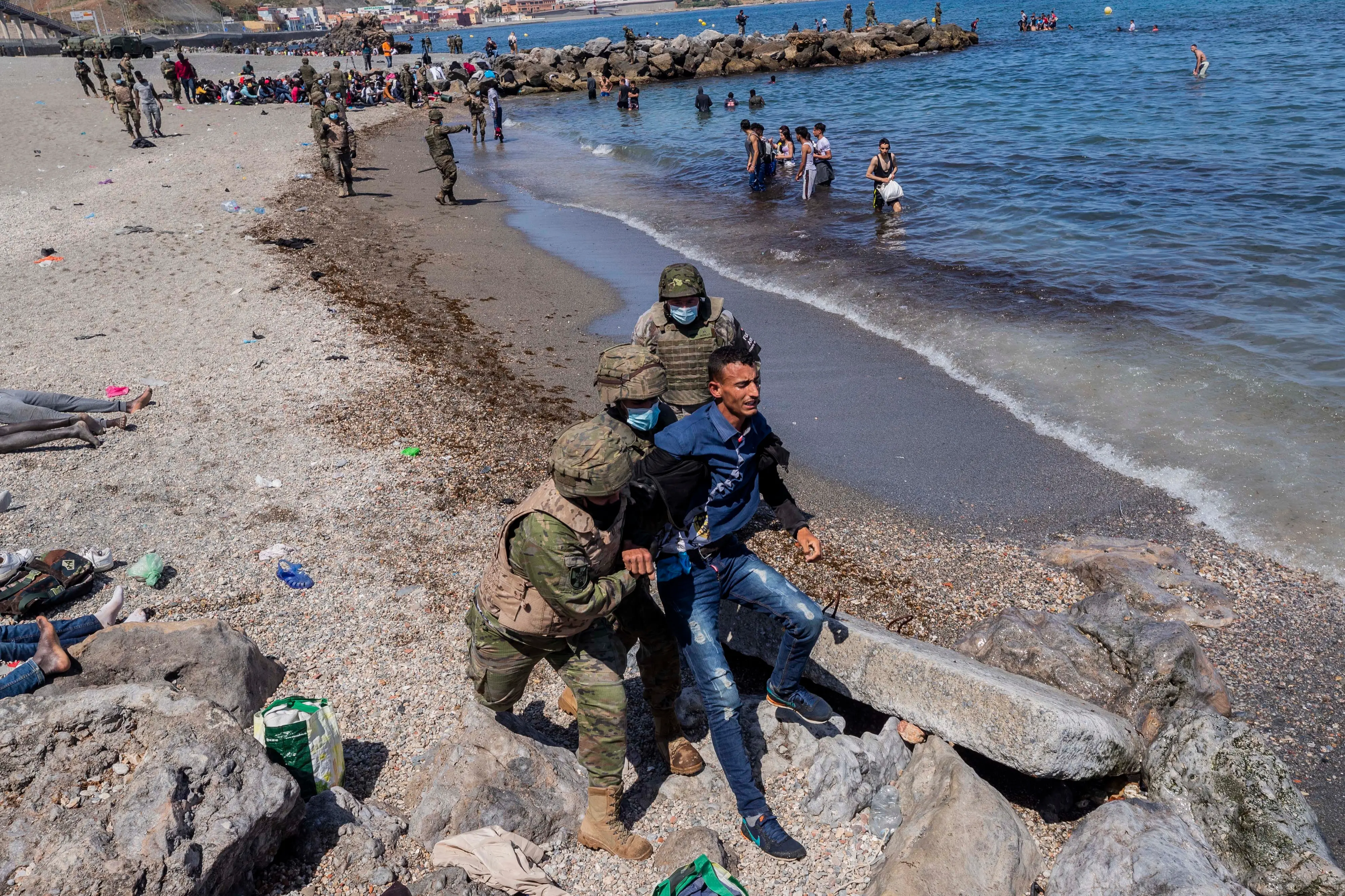 panish Army soldiers expel a migrant from the Spanish enclave of Ceuta, near the border of Morocco and Spain.| Photo: AP/PTI