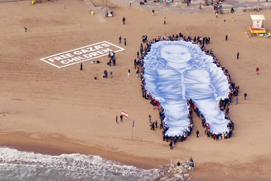 A close-up of the giant portrait of Hind Rajab, laid out on a Barcelona beach during a protest calling for urgent action to protect children in Gaza