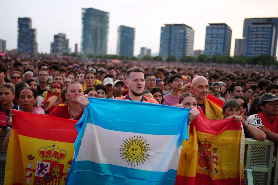 Spanish fans react while watching the World Cup final soccer match between Spain and Argentina on giant screens in Barcelona