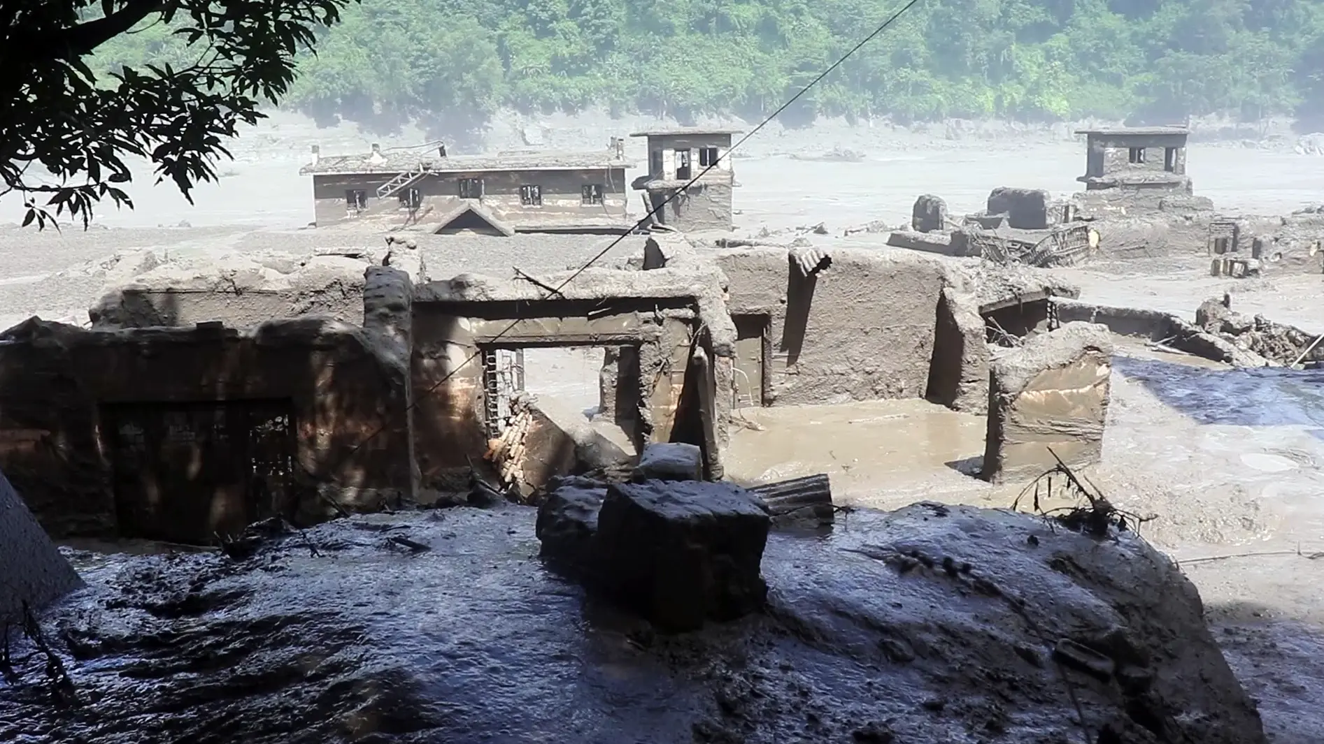 Houses and other structure devastated by mud-laden floodwaters following a flash flood caused by an outburst in the Bhotekoshi River
