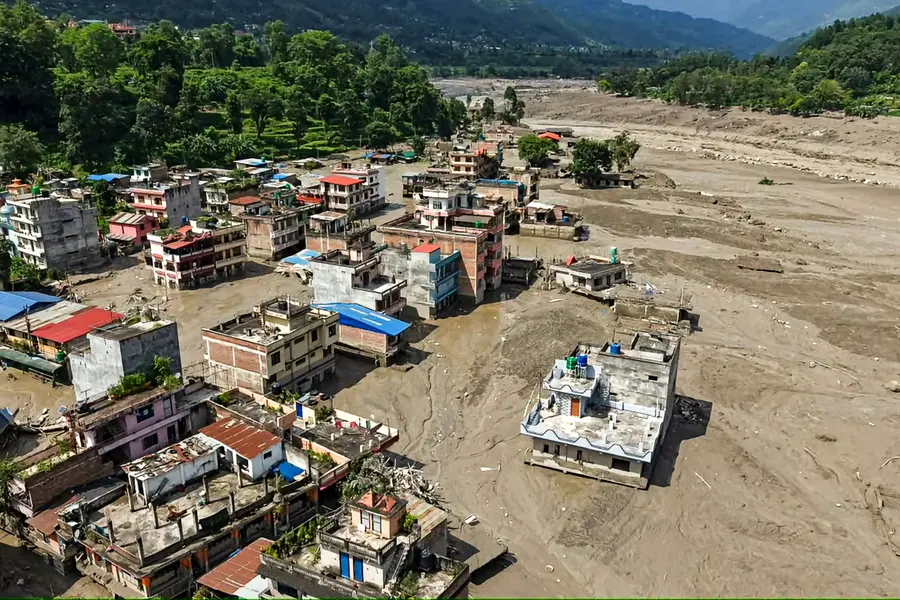 A view of structures standing partially submerged in a thick layer of mud and debris following flash floods at Beni Ghat area