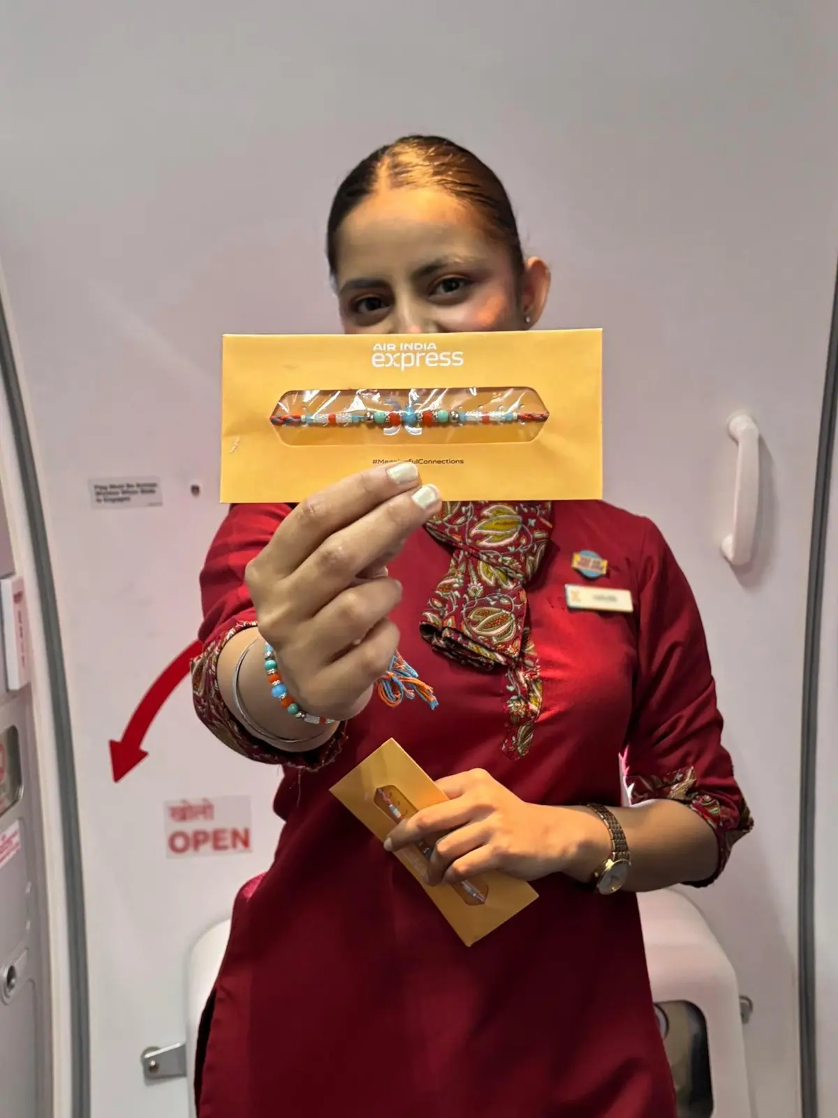 An air hostess holds a Rakhi on board an Air India Express flight