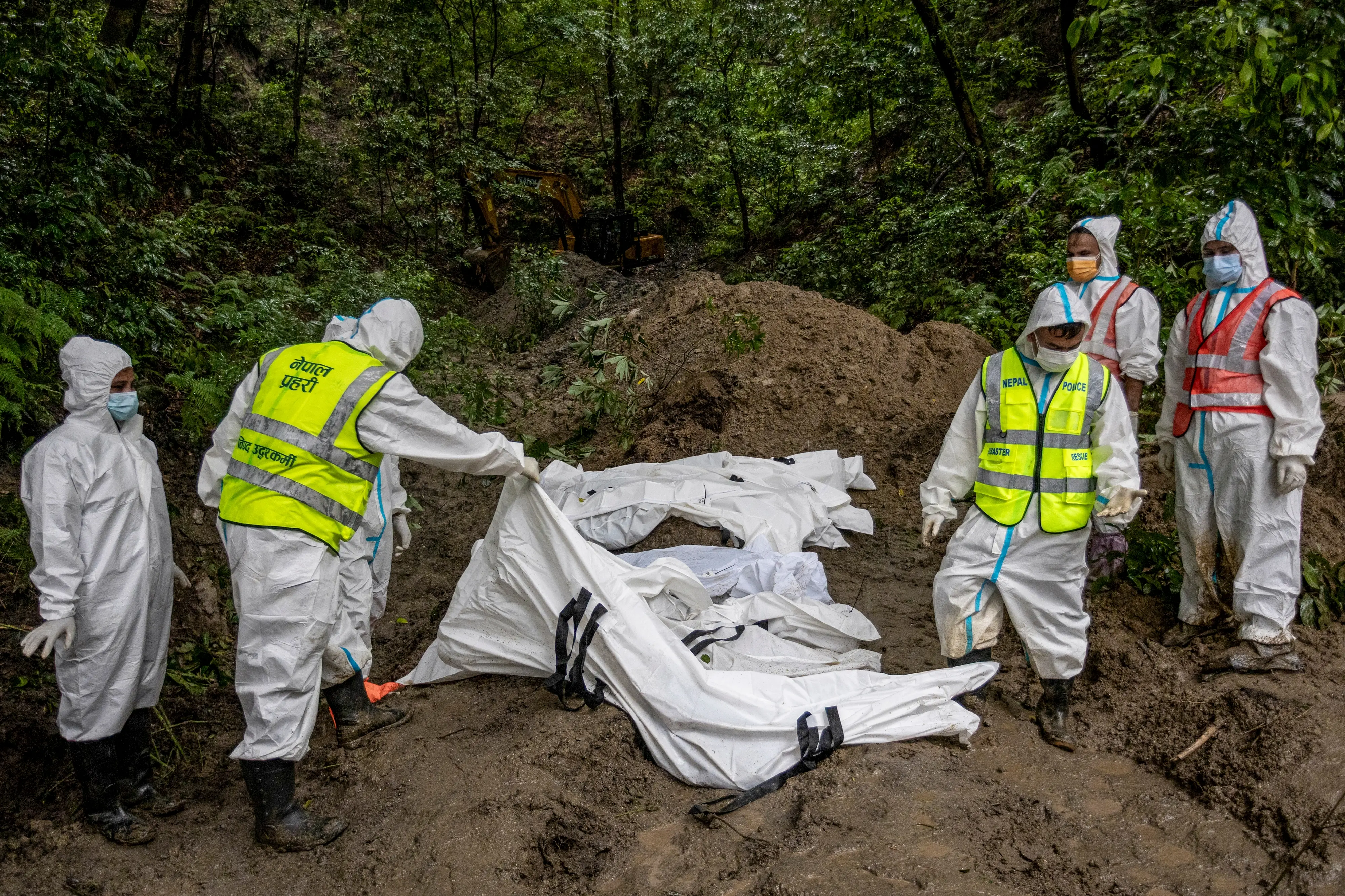 Security personnel prepare a mass burial site containing the bodies of victims of deadly flash floods and mudslides, in Gokarna, Kathmandu, Nepal.| Photo: PTI