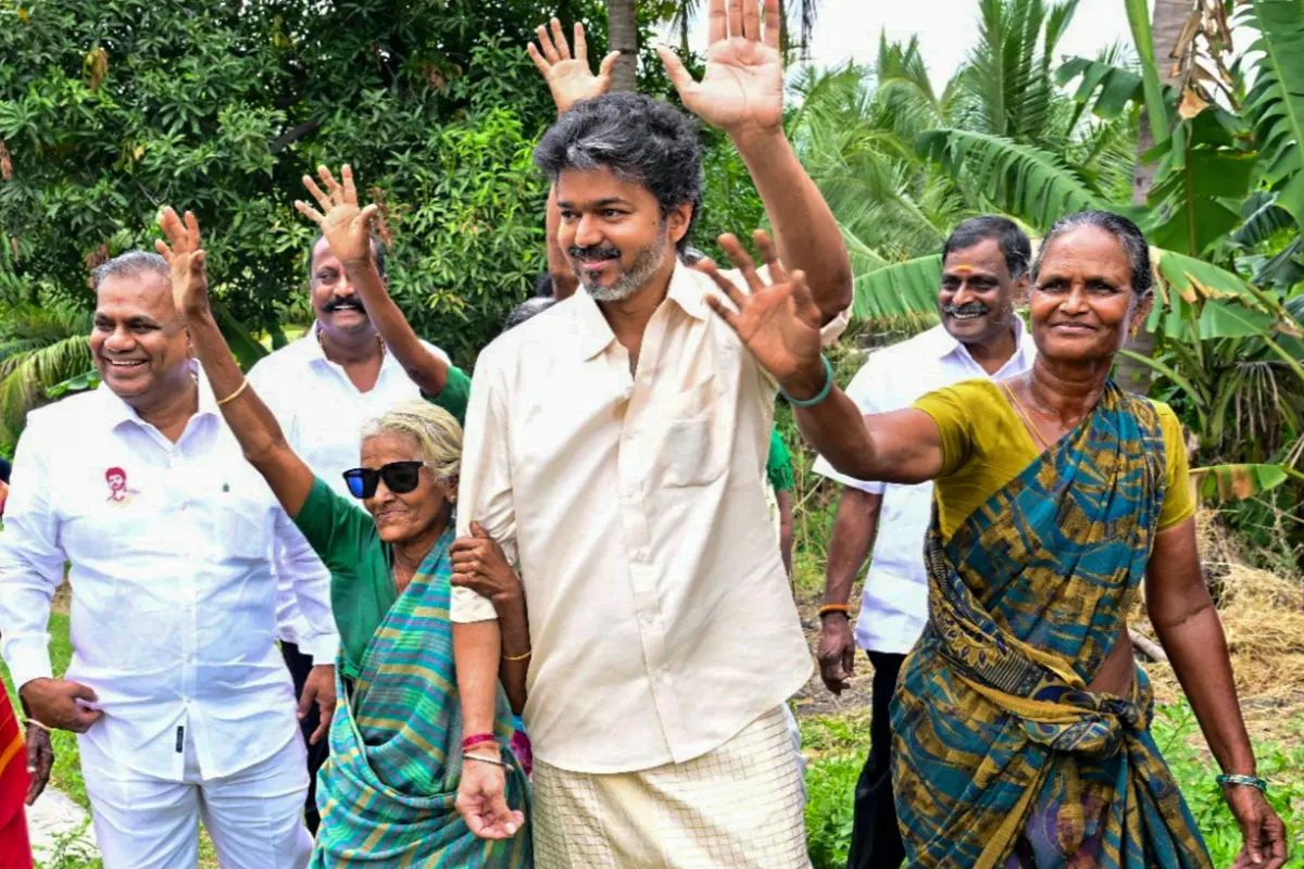 Tamil Nadu Chief Minister C Joseph Vijay adjusts sunglasses on an elderly woman during his visit to the residence of a farmer, P. Ramasamy, at Chinnakkavoor village, in Salem district, Tamil Nadu.| Photo: PTI