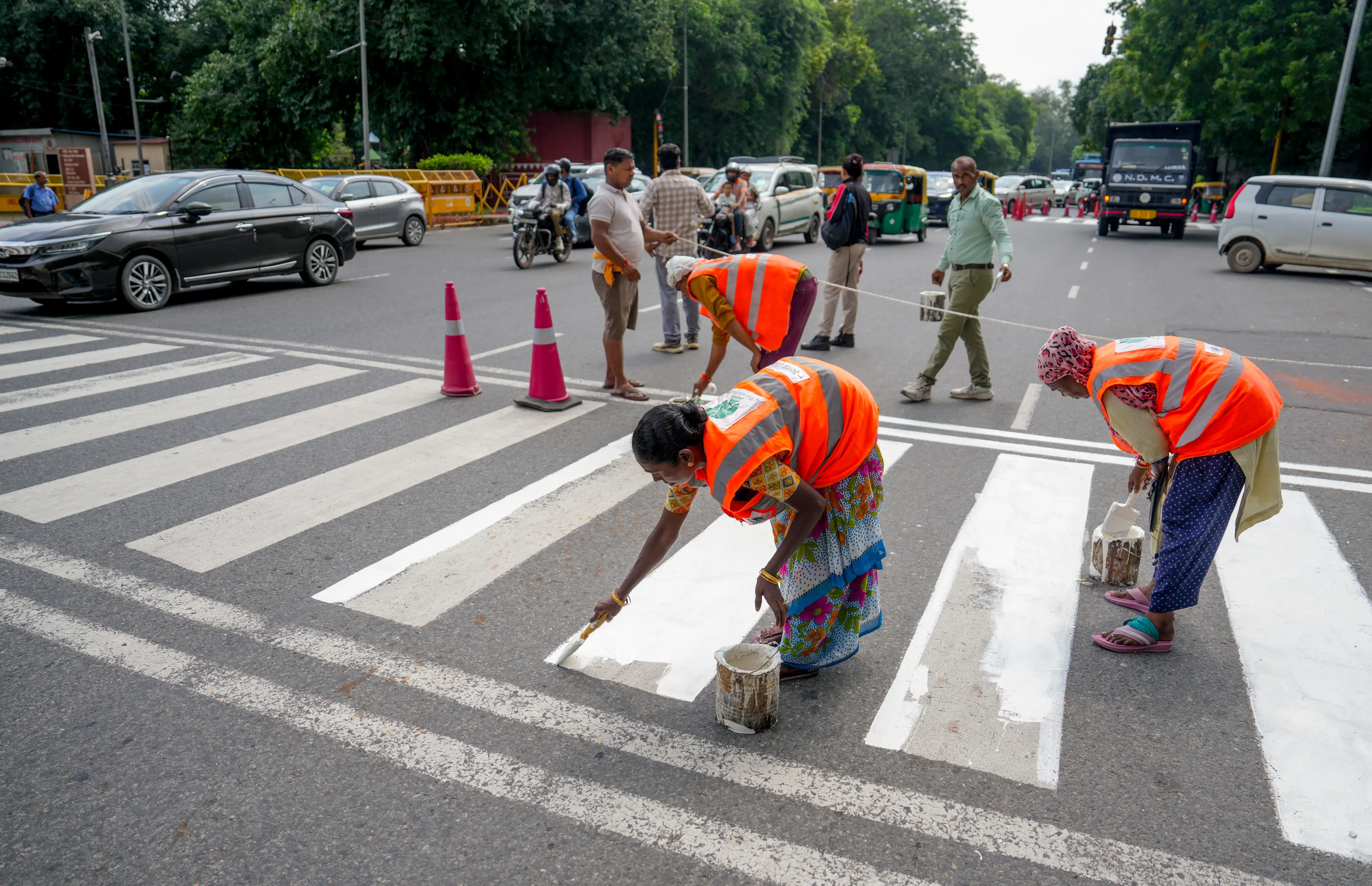 NDMC workers mark zebra crossing at India Gate circle ahead of the 18th BRICS Summit, scheduled to be held on Sept. 12th to 13th, in New Delhi.| Photo: PTI