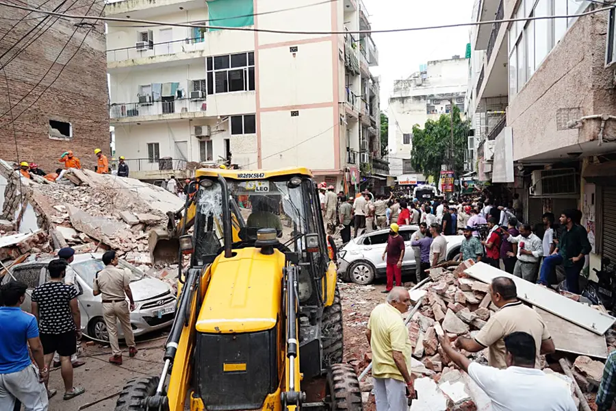 JCB machines carry out rescue operations at the site of a building collapse at Satya Niketan in South-West Delhi