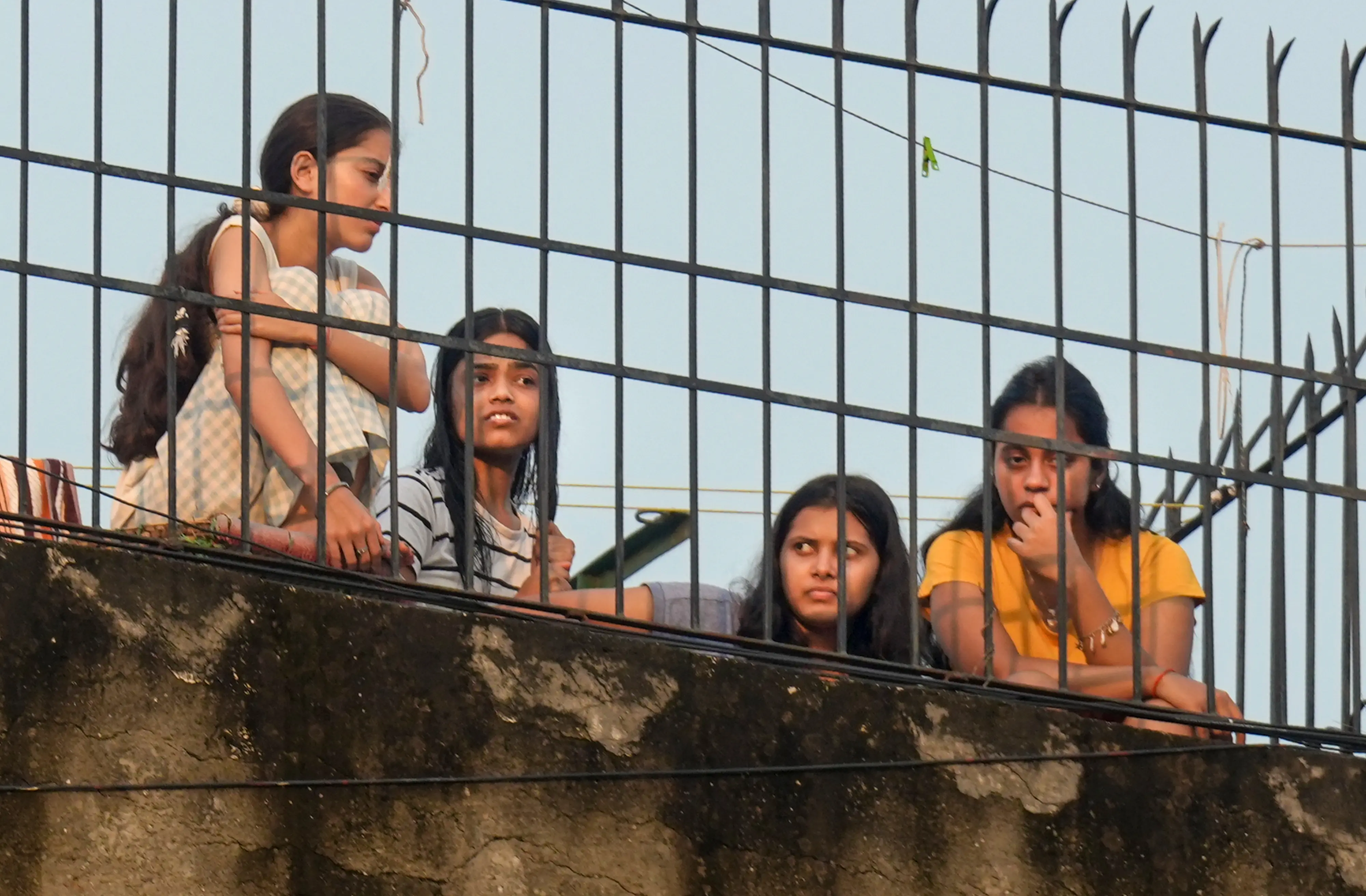 Neighbours look on during a rescue operation after a 50-year-old five-storey building housing a boys' hostel collapsed in a congested bylane in Satya Niketan near Delhi University's south campus