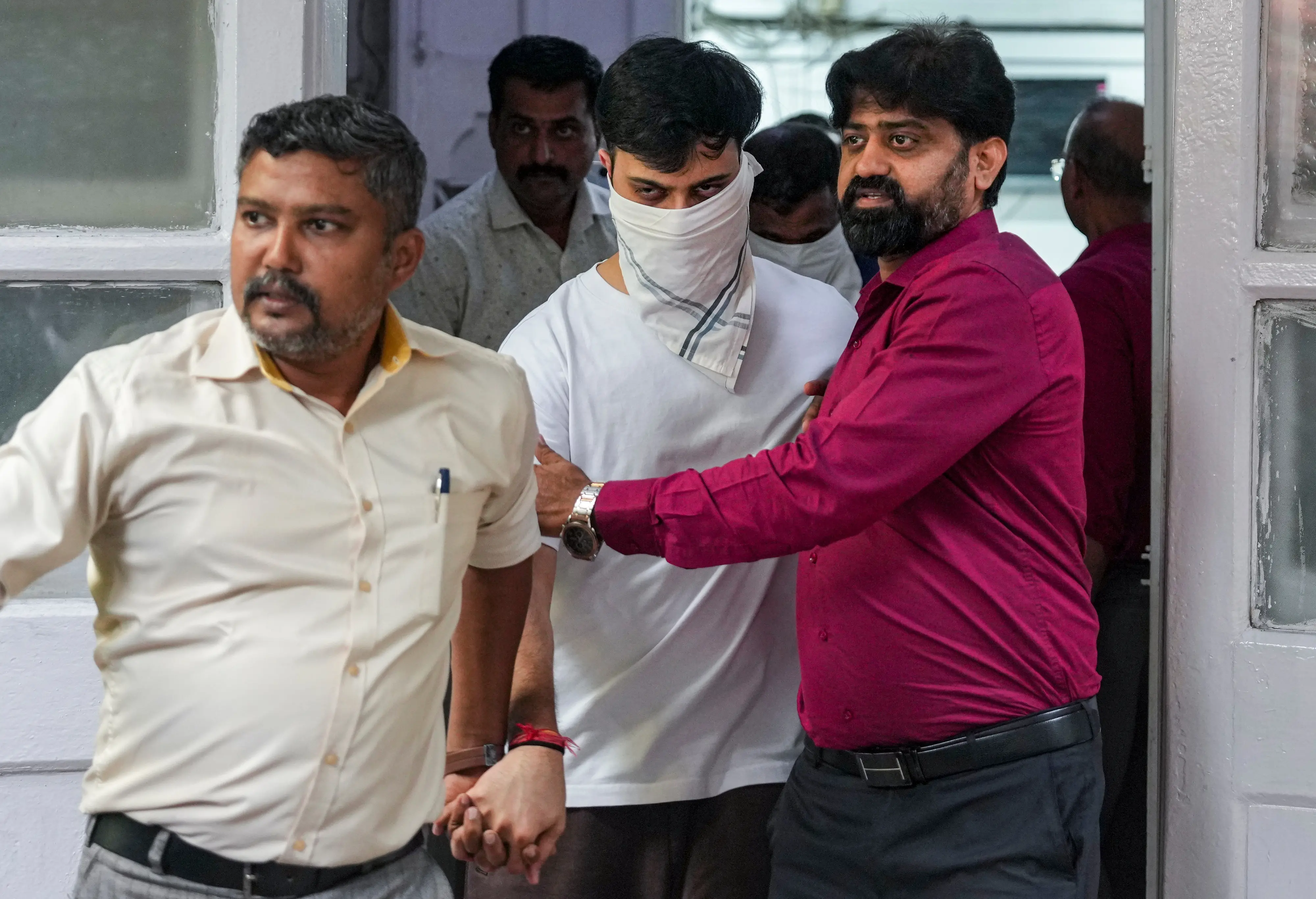 Police officials arrest Rohan Parekh, white mask, a 24-year-old man, after he claimed to be a PMO official and allegedly forced entry at a shopping mall in Bandra-Kurla Complex (BKC) | PTI