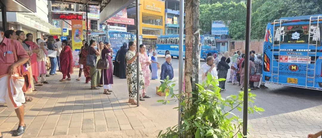 ചക്കരക്കല്ല് ബസ് സ്റ്റാൻഡിൽ യാത്രക്കാർ കടവരാന്തയിലും മറ്റും ബസ് കാത്തുനിൽക്കുന്നു
