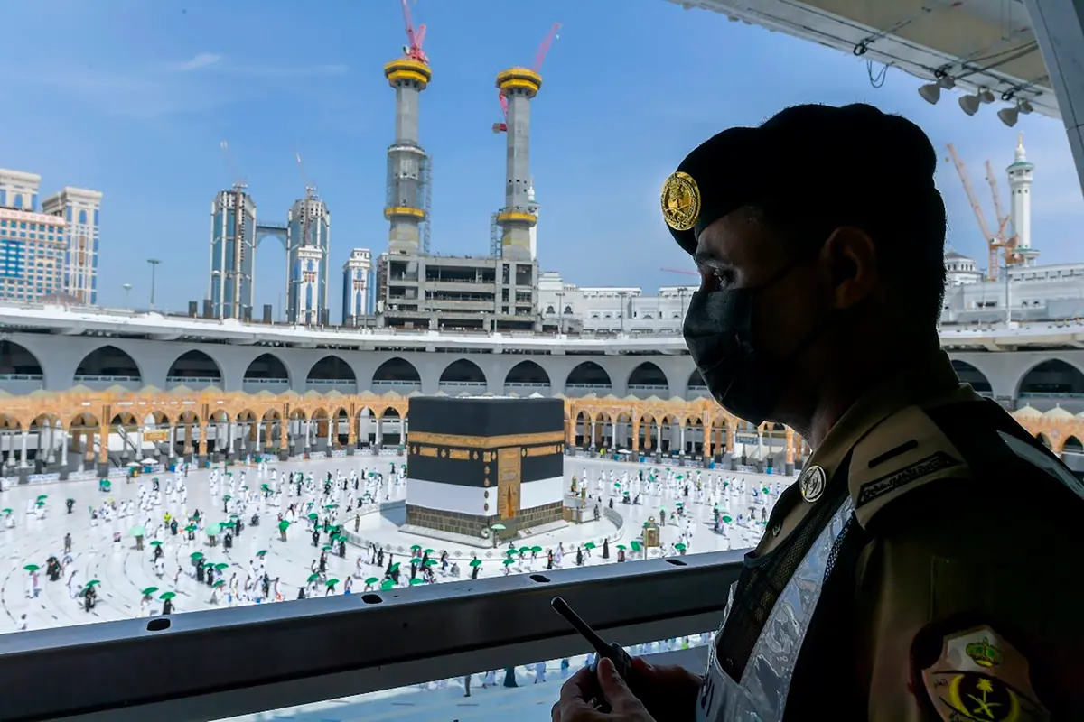 A Saudi security officer watches as Muslim hajj pilgrims, wearing masks and keeping social distancing to help prevent the spread of the coronavirus, circumambulate the Kaaba, a square stone structure in the Great Mosque, in Mecca Saudi Arabia during pandemic period | File photo: PTI