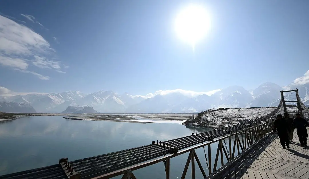 People cross the Kowardu suspension bridge over the Indus River (Photo: AFP)