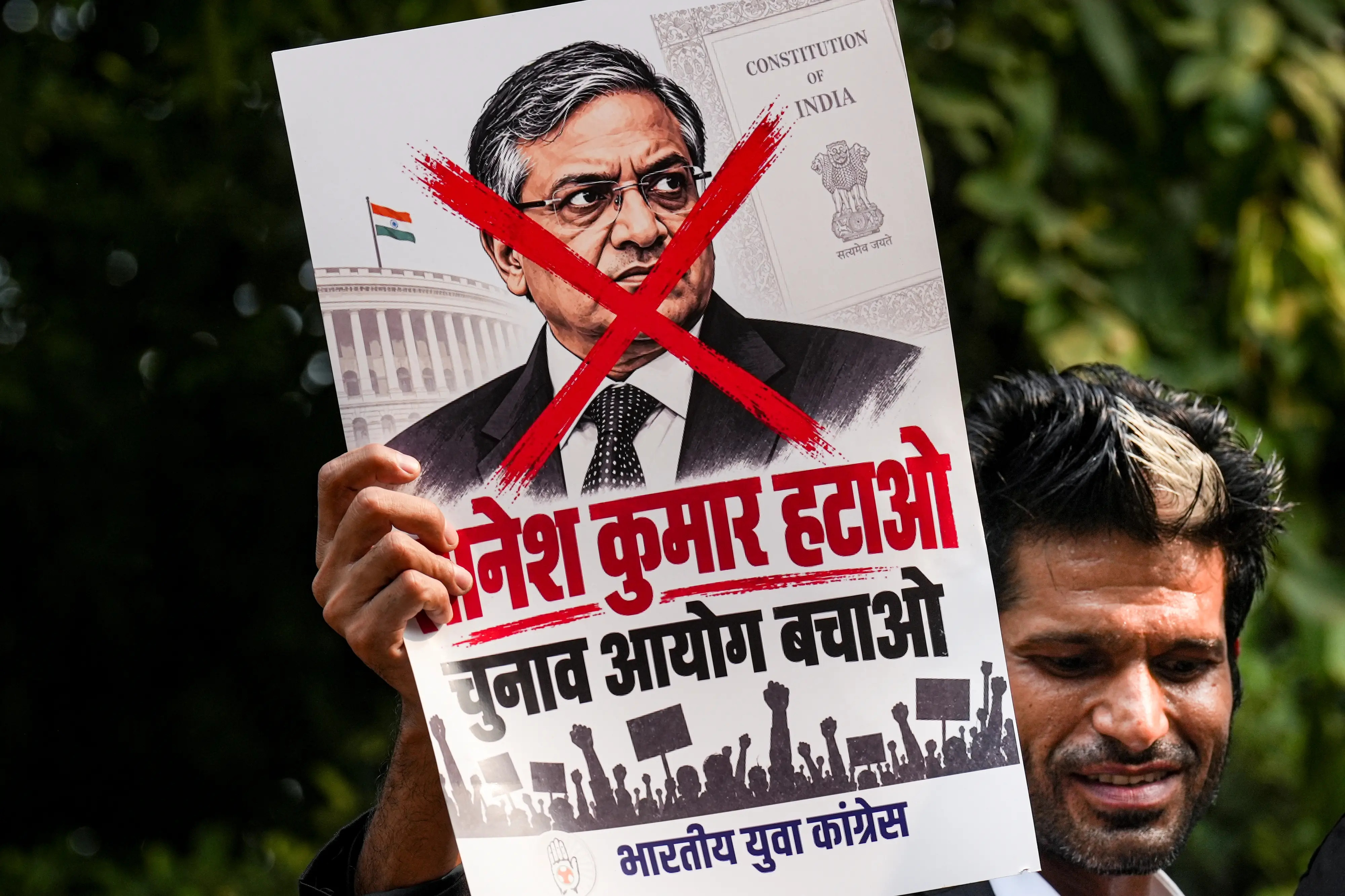 A protestor holds a poster of Chief Election Commissioner (CEC) Gyanesh Kumar during a protest by Indian Youth Congress (IYC) members against the CEC, in New Delhi.| Photo: PTI