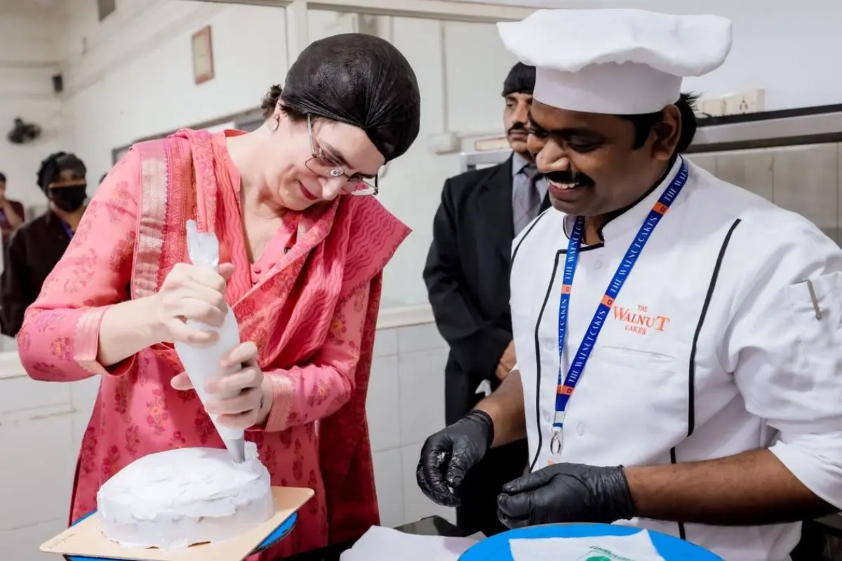 Priyanka Gandhi icing a cake at a KINFRA event in Wayanad | Photo: X