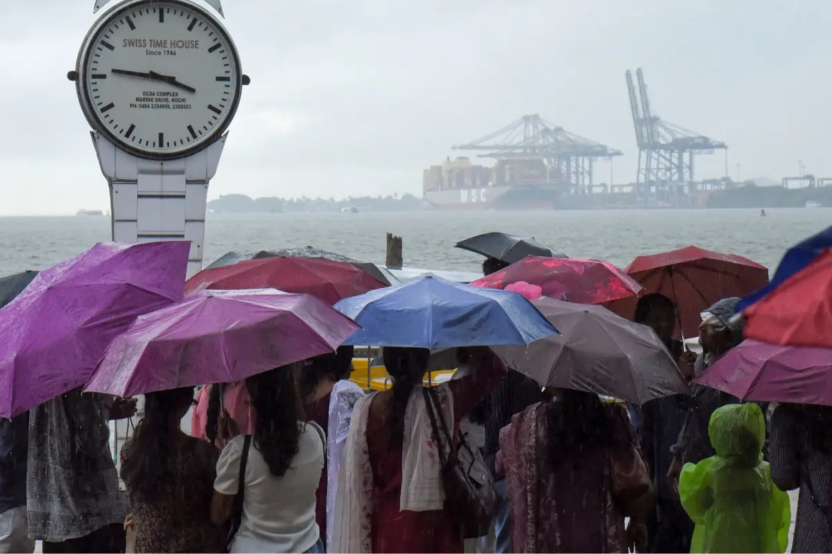 Visitors at the Marine Drive on a rainy afternoon, in Kochi.| Photo: PTI