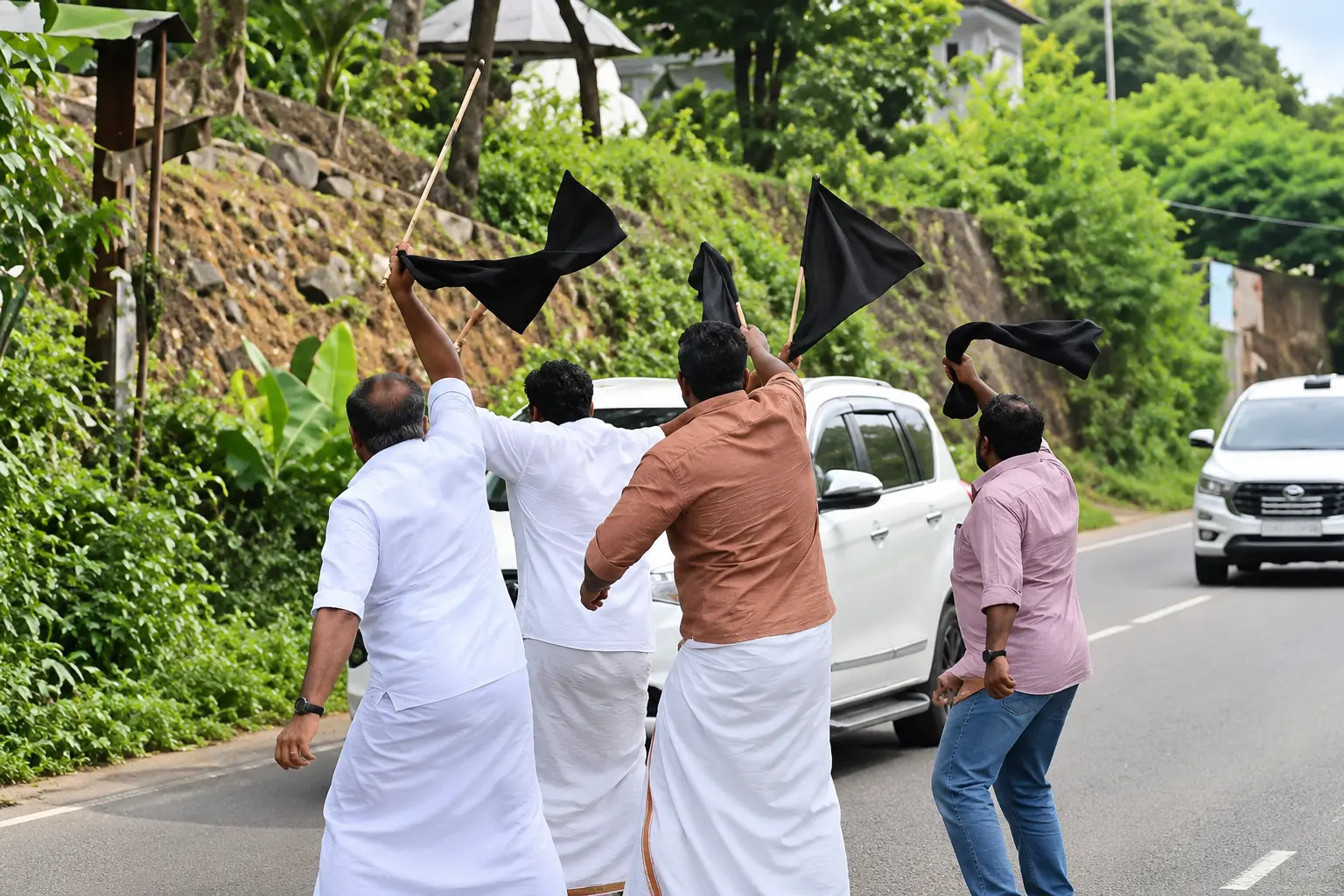 Youth Front (M) activists wave black flags as Chief Minister V D Satheesan's convoy passes through Idukki on Friday.