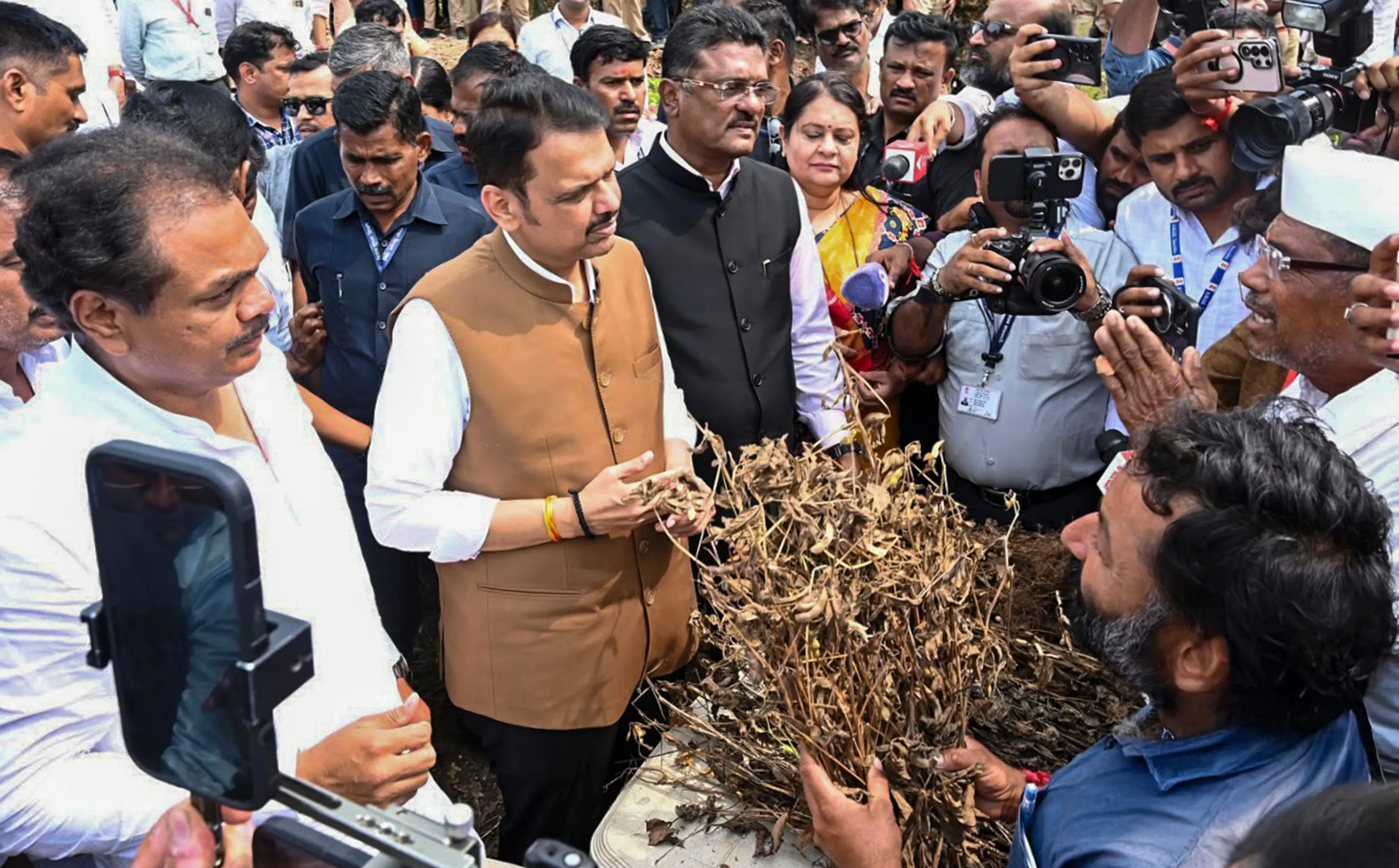 Maharashtra Chief Minister Devendra Fadnavis during an inspection of areas affected by the drought-like situation in Malkapur, Kalamb Taluka and Dharashiv district. State Minister Pratap Sarnaik, MLA Ranajagjitsinha Patil and others are also present | Photo: PTI