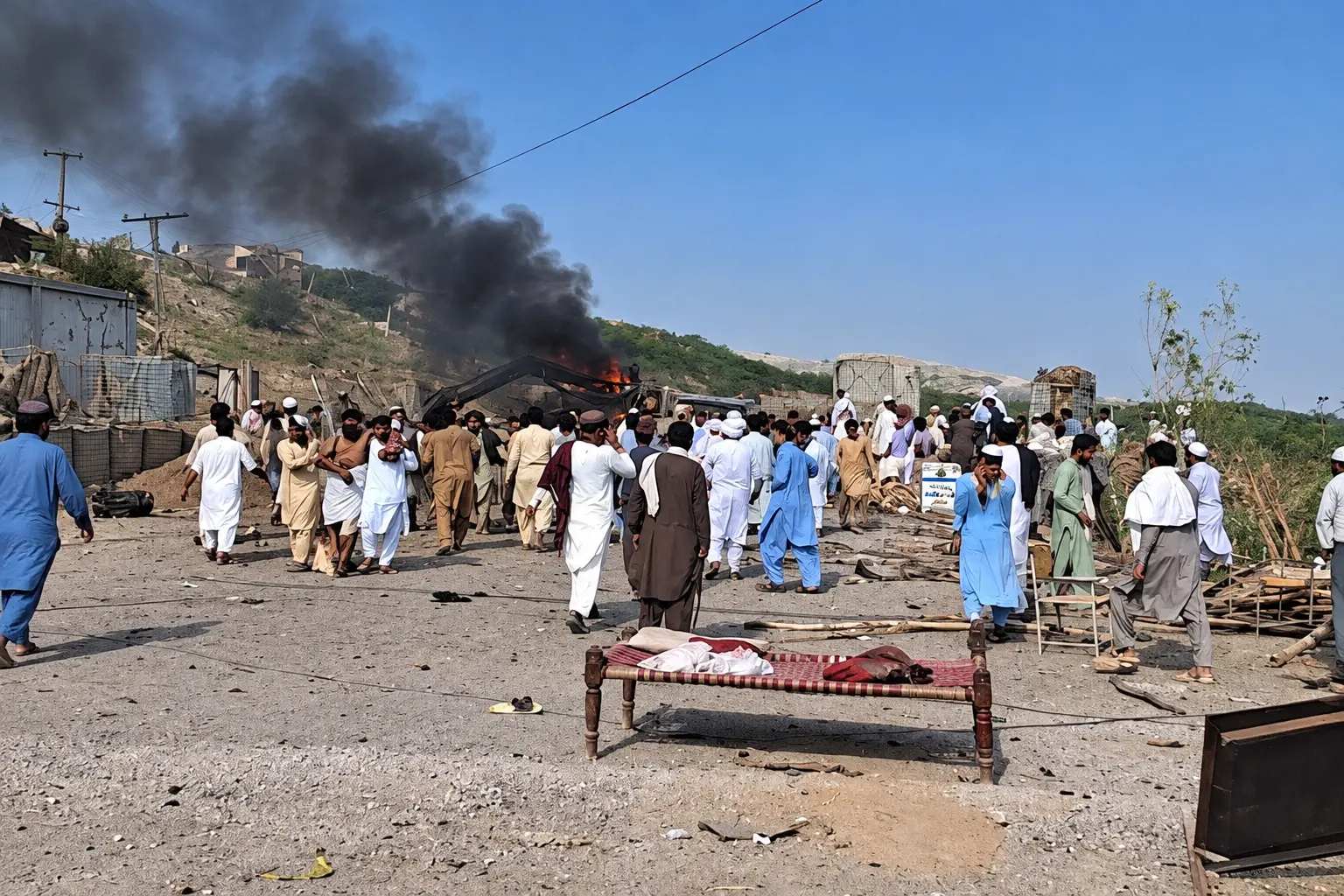 Smoke rises from the site of a suspected suicide bombing at a roadside police checkpoint in Dera Ismail Khan, Pakistan, after the blast killed at least 11 people and injured around 30 others.