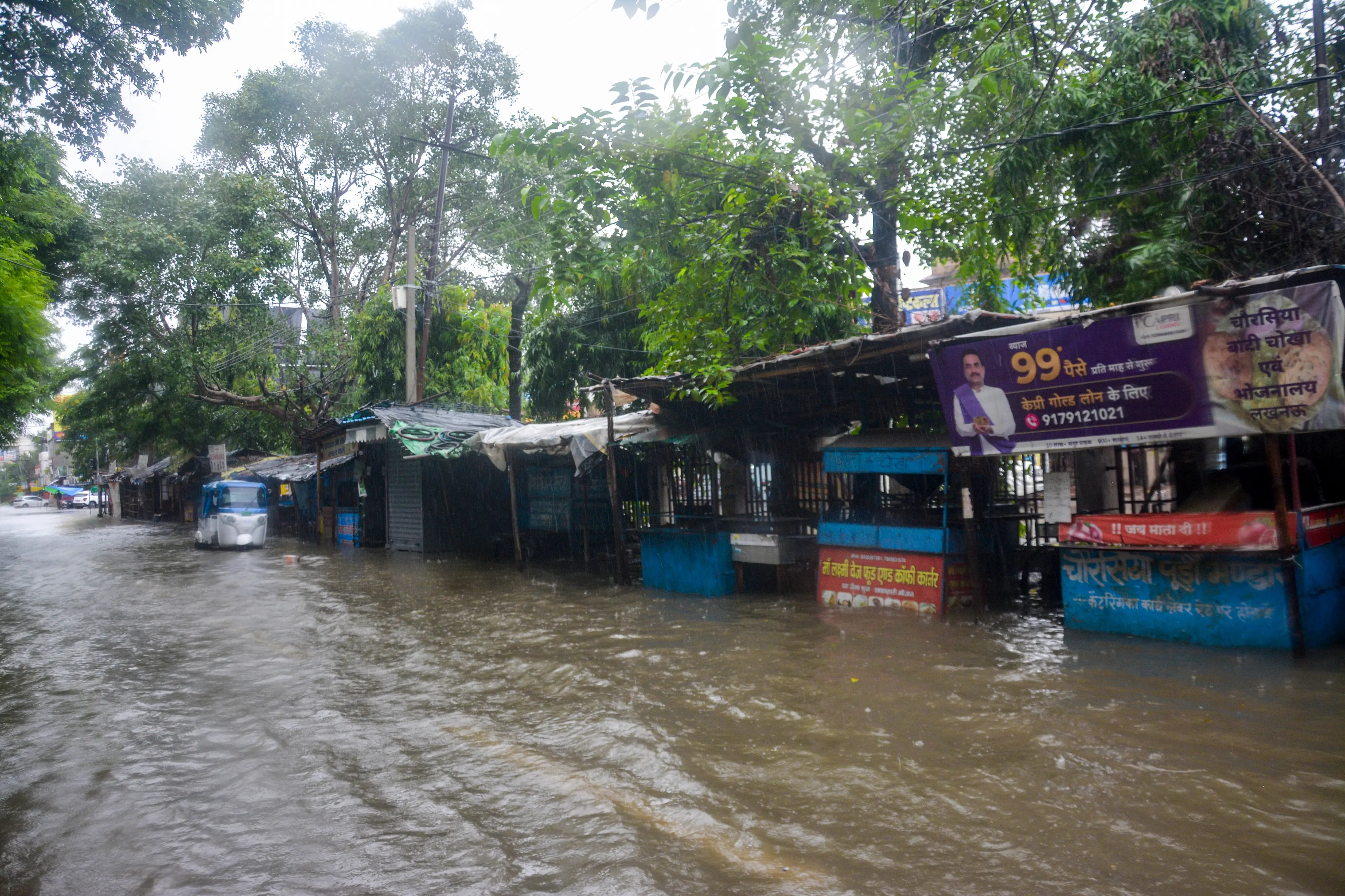An auto-rickshaw moves through a waterlogged road amid rainfall, in Lucknow, Uttar Pradesh | Photo: PTI