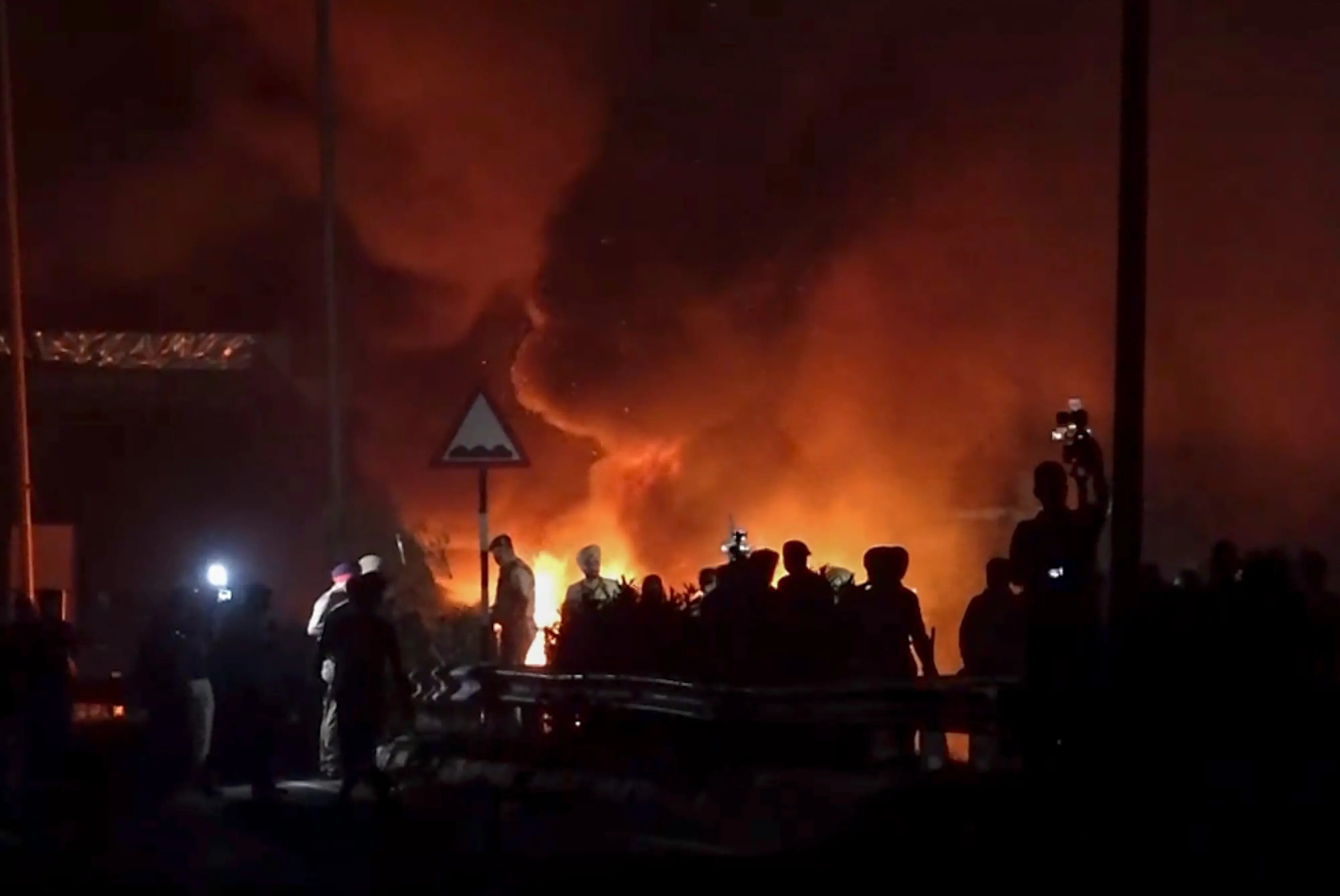 Smoke billows from a fire during a protest by students at the Lovely Professional University (LPU) campus