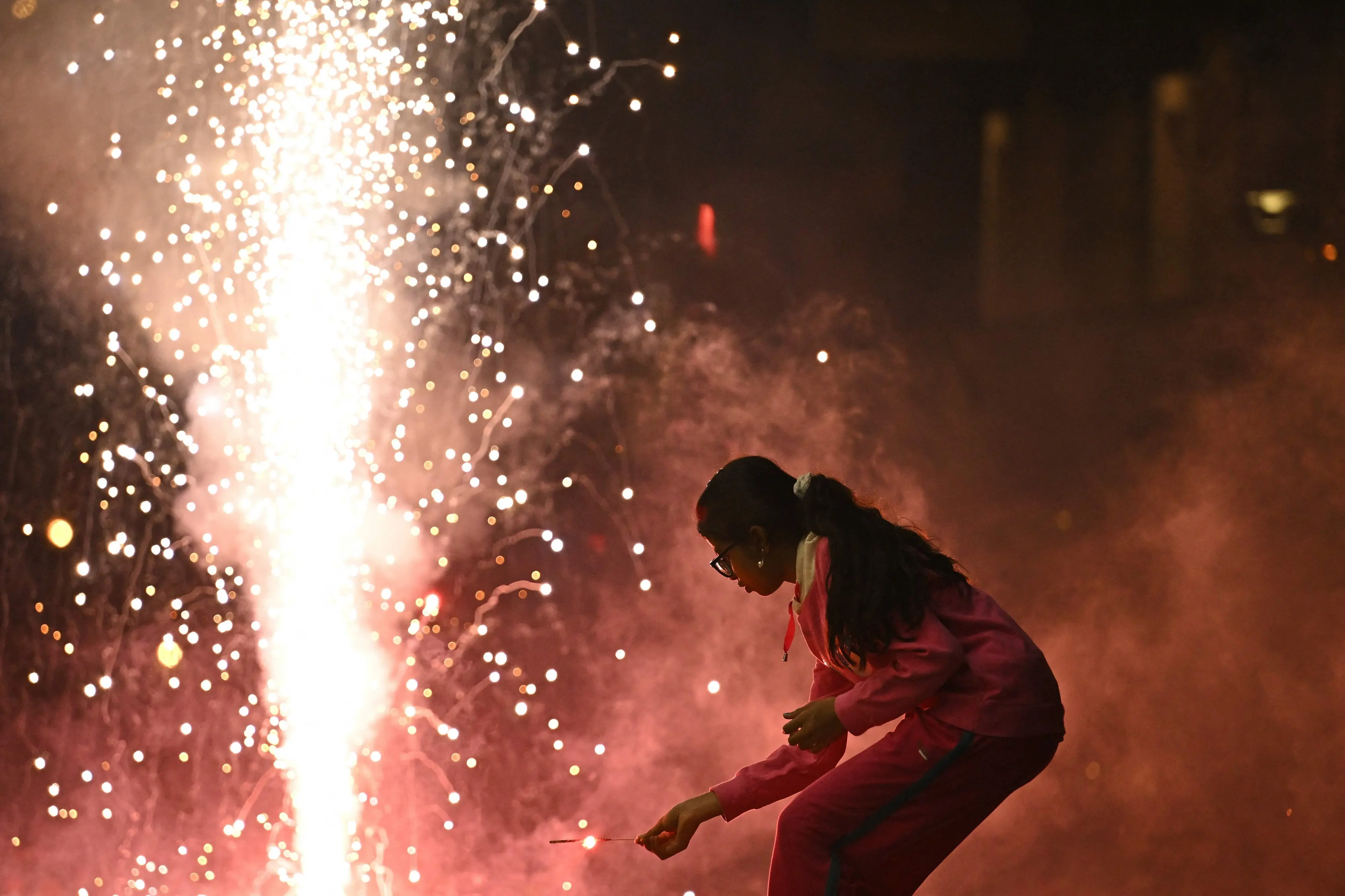 A child lights a firecracker during the Diwali, a Hindu festival of lights, in Bengaluru.| Photo: PTI