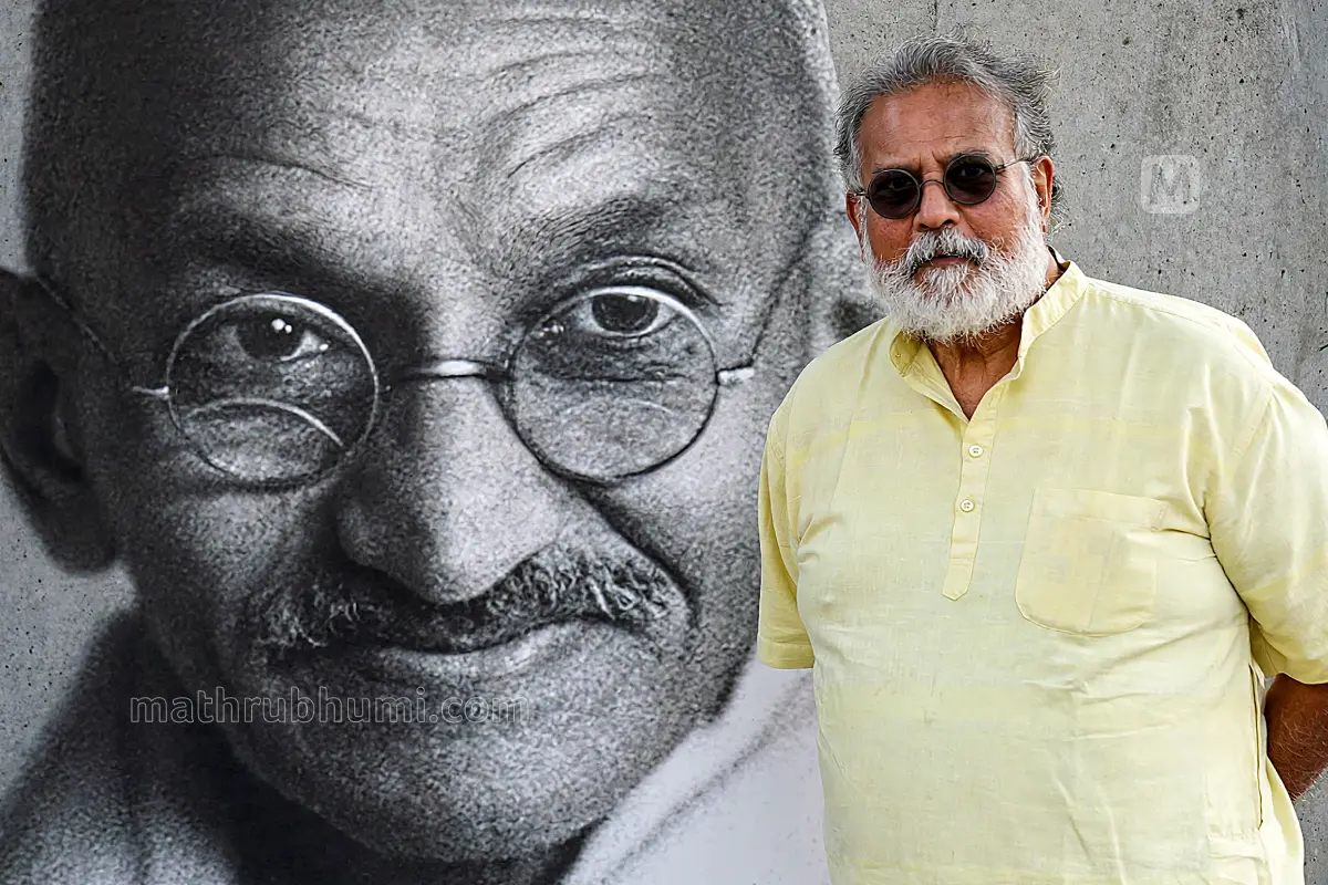 തുഷാർ ഗാന്ധി, പശ്ചാത്തലത്തിൽ മഹാത്മാഗാന്ധിയുടെ ചിത്രം | Photo: Mathrubhumi
