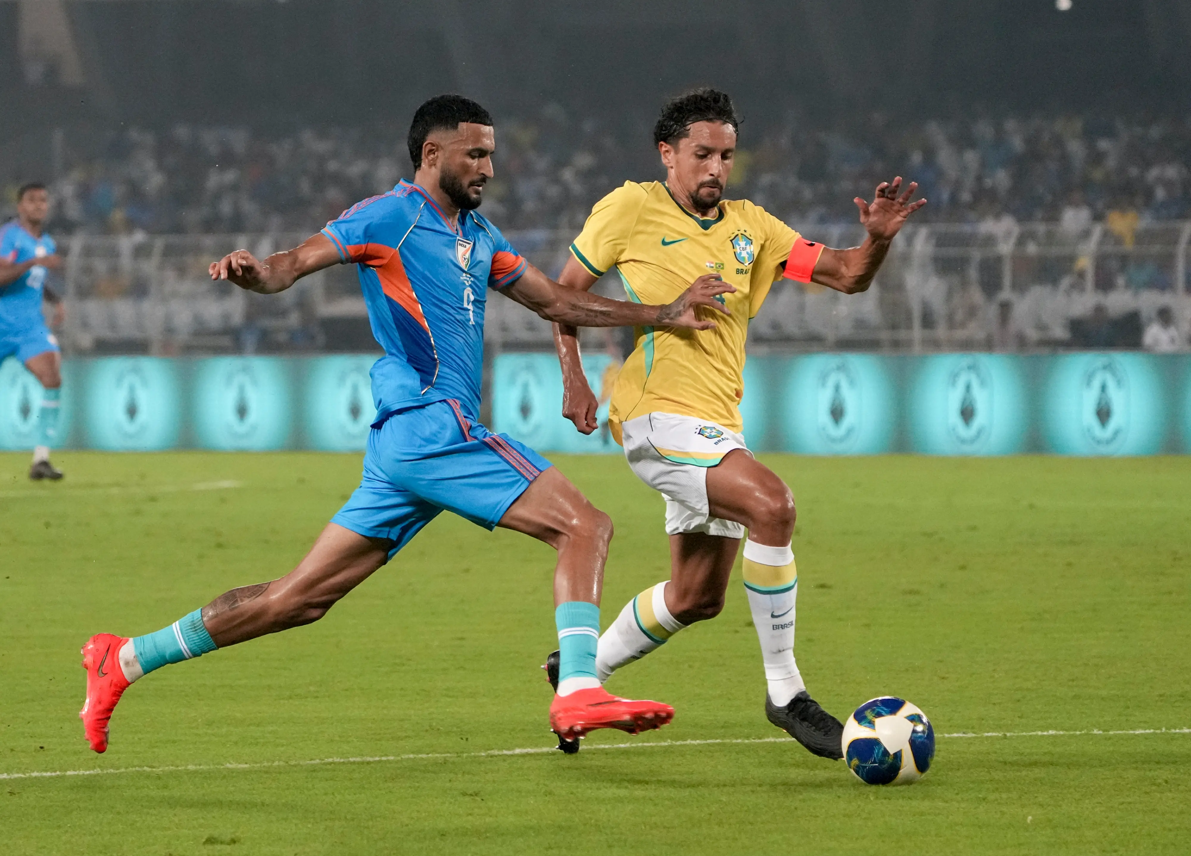India's Manvir Singh, blue, and Brazil's captain Marquinhos vie for the ball during an International friendly Football match between India and Brazil, in Kolkata.| Photo: PTI