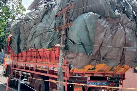പാഴ്സൽ ലോറി വൈദ്യുതത്തൂണിൽ കുടുങ്ങി
