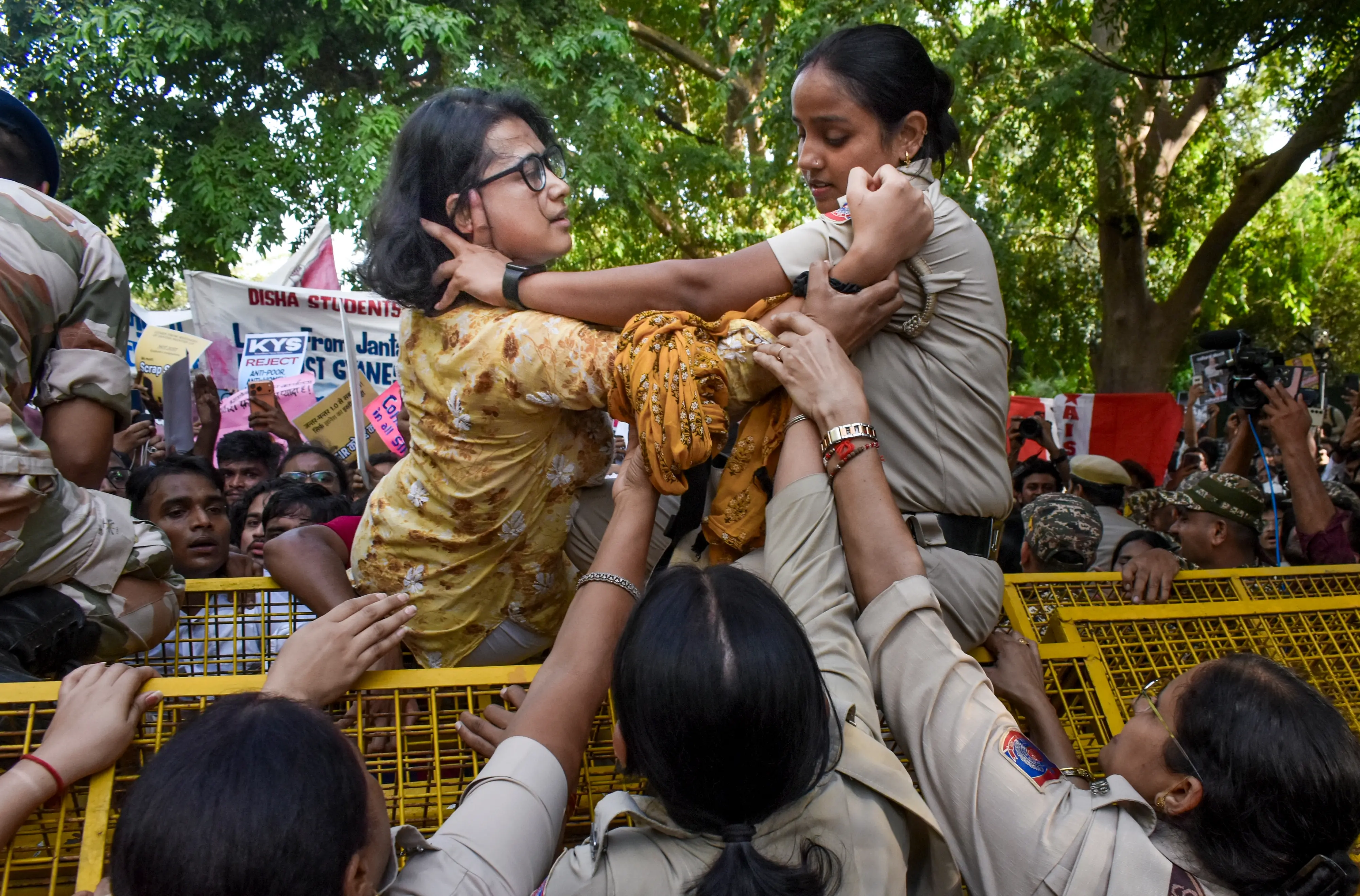 All India Students' Association (AISA) national president Neha Bora climbs a police barricade near Ashoka Road as student activists attempt to march towards Jantar Mantar | PTI