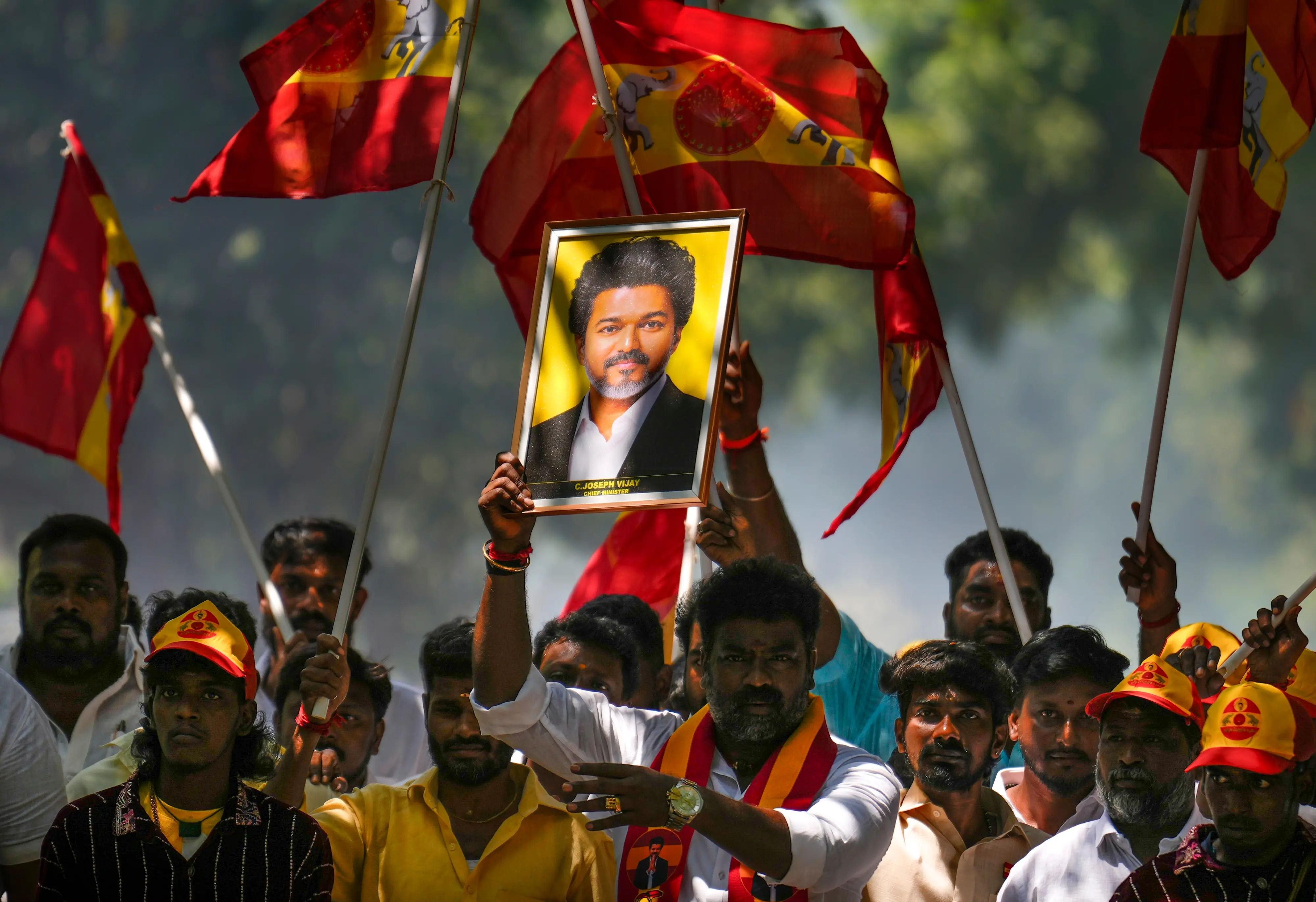 Tamilaga Vettri Kazhagam (TVK) supporters hold a portrait of party President and Tamil Nadu Chief Minister C Joseph Vijay amid the counting of votes for Maduranthagam and Dharapuram Assembly by-elections, outside TVK headquarters, in Chennai.| Photo: PTI