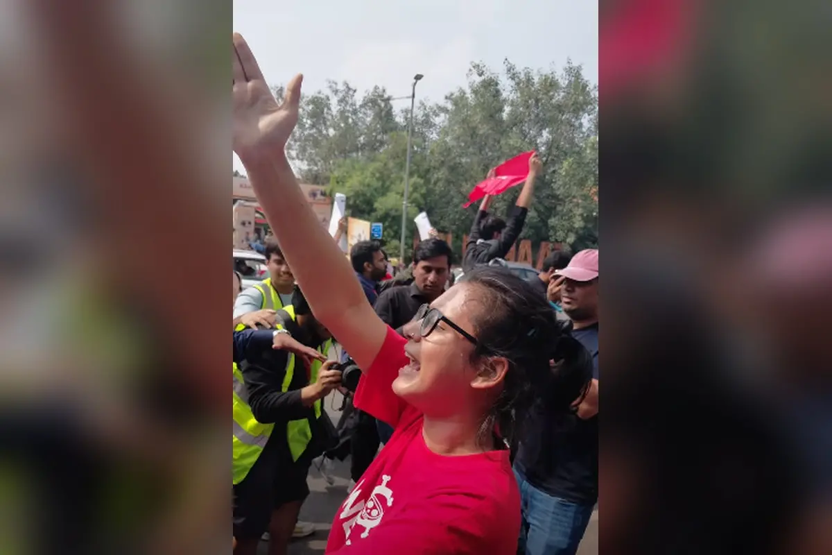 AISA president Neha Bora raising her hand and chanting slogans during the ongoing CJP protest in Delhi on October 10, demanding Chief Election Commissioner Gyanesh Kumar's resignation and the rollback of the Special Intensive Revision (SIR) of electoral rolls.
