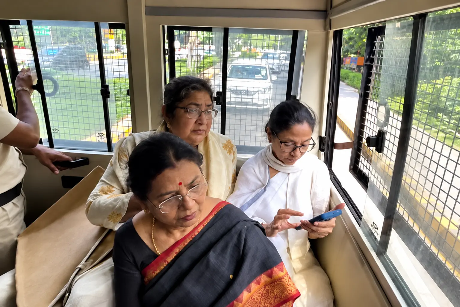 Former West Bengal Chief Minister Mamata Banerjee, and MP Mala Roy sit inside a police vehicle after being taken away from the protest site at Jantar Mantar in New Delhi.