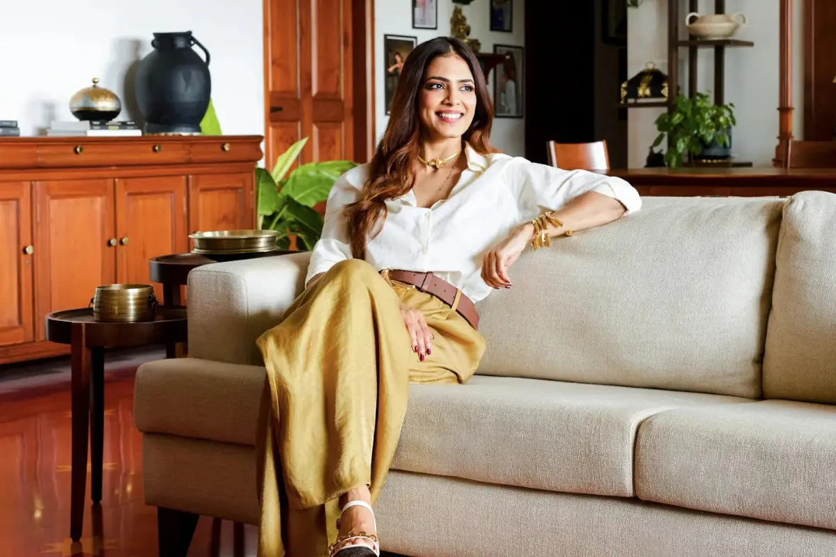 Malavika Mohanan in her living room, seated on a sofa from Tianu Furniture. The side tables are from the same brand.