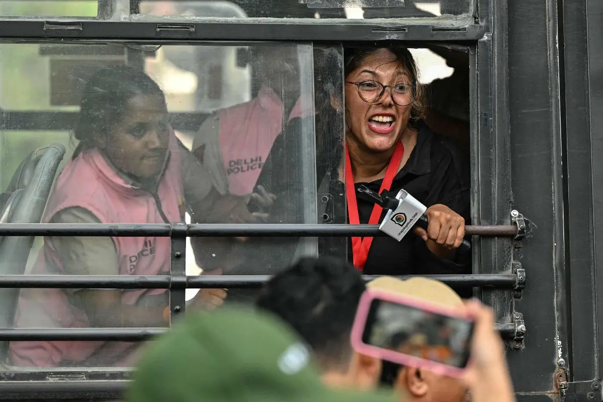Police personnel detain a journalist (R) during a protest demanding the resignation of India's Chief Election Commissioner Gyanesh Kumar over alleged voter roll irregularities linked to the "special intensive revision" (SIR), in New Delhi on October 11, 2026