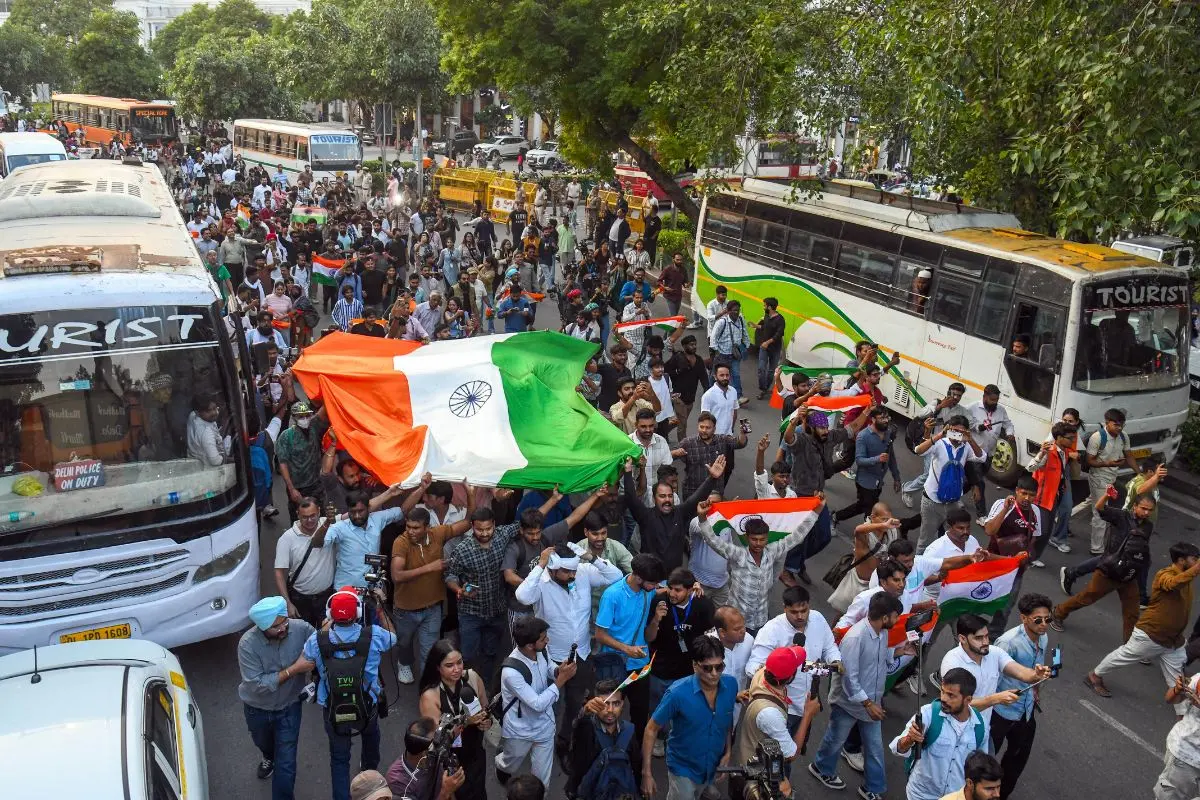 CJP supporters hold a large Tricolour as they gather in large numbers near Connaught Place during the Tiranga March, in New Delhi on Friday.