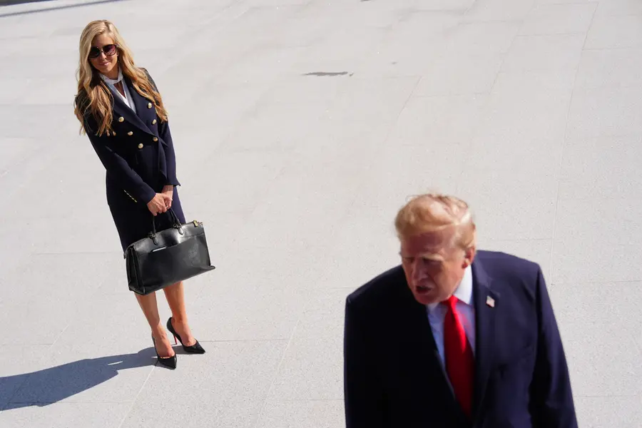 President Donald Trump speaks to the reporters as he walks to board Marine One on the South Lawn of the White House, Tuesday, Oct. 13, 2026, in Washington, as White House press secretary Katie Zacharia looks on
