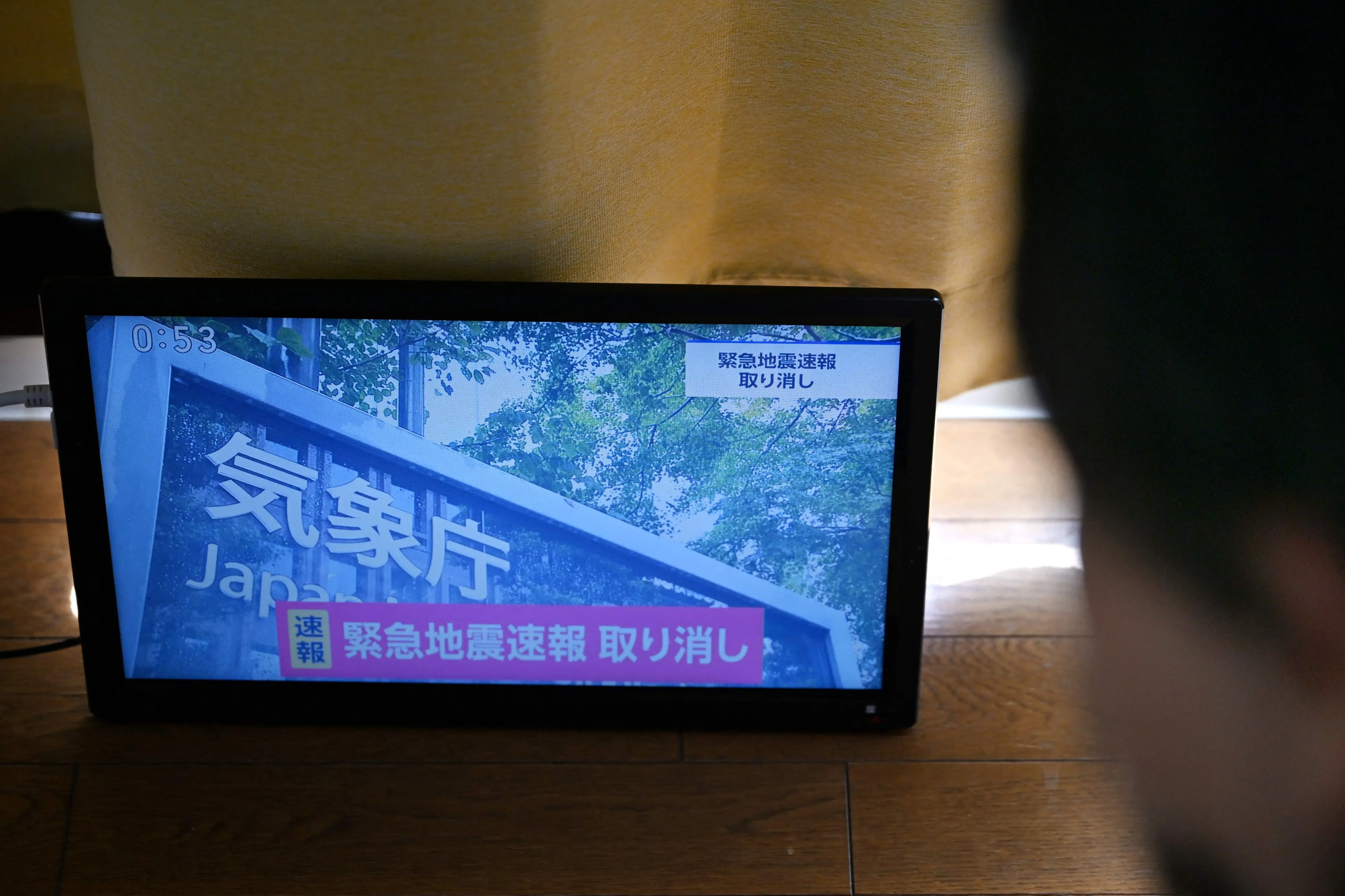 An advisory that reads "Emergency Earthquake Alert Cancelled" is seen on a television screen in Tokyo on October 16, 2026 | AFP