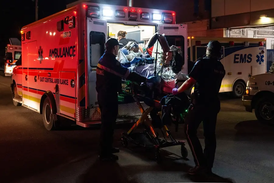 Paramedics load an injured person into an ambulance at the Wainwright Health Centre as injured military members are treated after a fire at Canadian Forces Base Wainwright, outside of Wainwright, Alberta