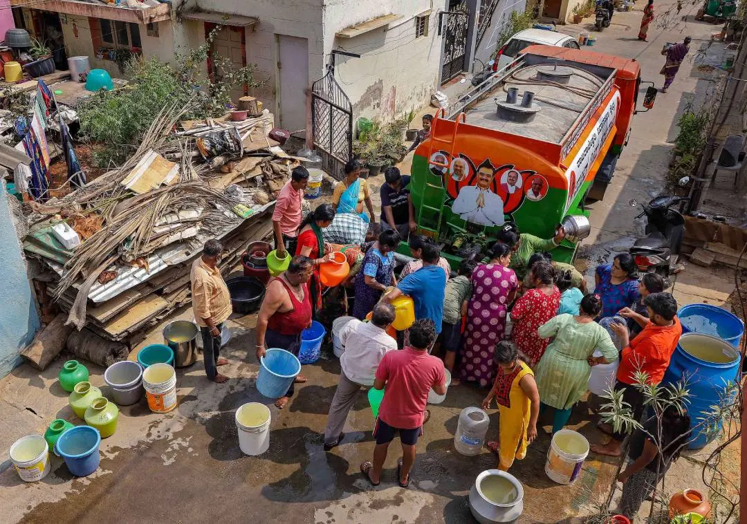 ടാങ്കറിലെത്തിക്കുന്ന വെള്ളത്തിനായി കാത്തുനില്ക്കുന്നവര് | Photo : PTI