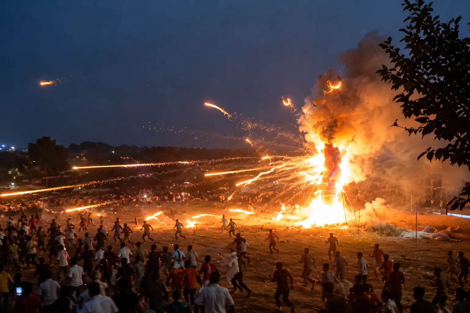 A burning Ravana effigy sends fireworks flying towards spectators during a Dussehra celebration, forcing people to run for safety.