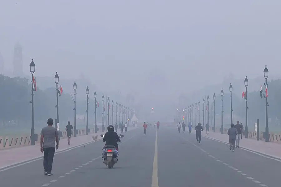 People jog amid dense smog near the India Gate and Kartavya Path