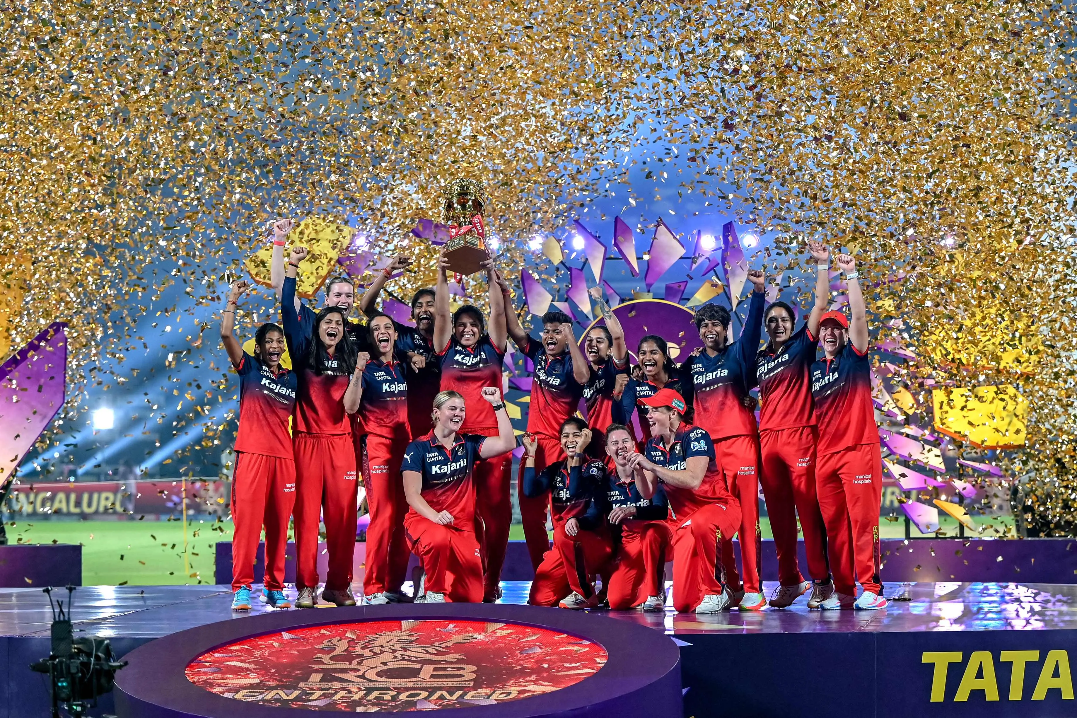 Royal Challengers Bengaluru's players celebrate with the trophy after winning the 2026 Women's Premier League (WPL) Twenty20 final cricket match against Delhi Capitals at the Kotambi Stadium in Vadodara.| File image: PTI