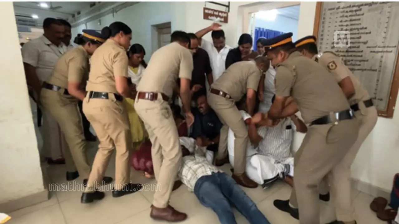 ഏറ്റുമുട്ടിയ ഭരണ-പ്രതിപക്ഷഅംഗങ്ങളെ പോലീസ് പിടിച്ചു മാറ്റുന്നു.