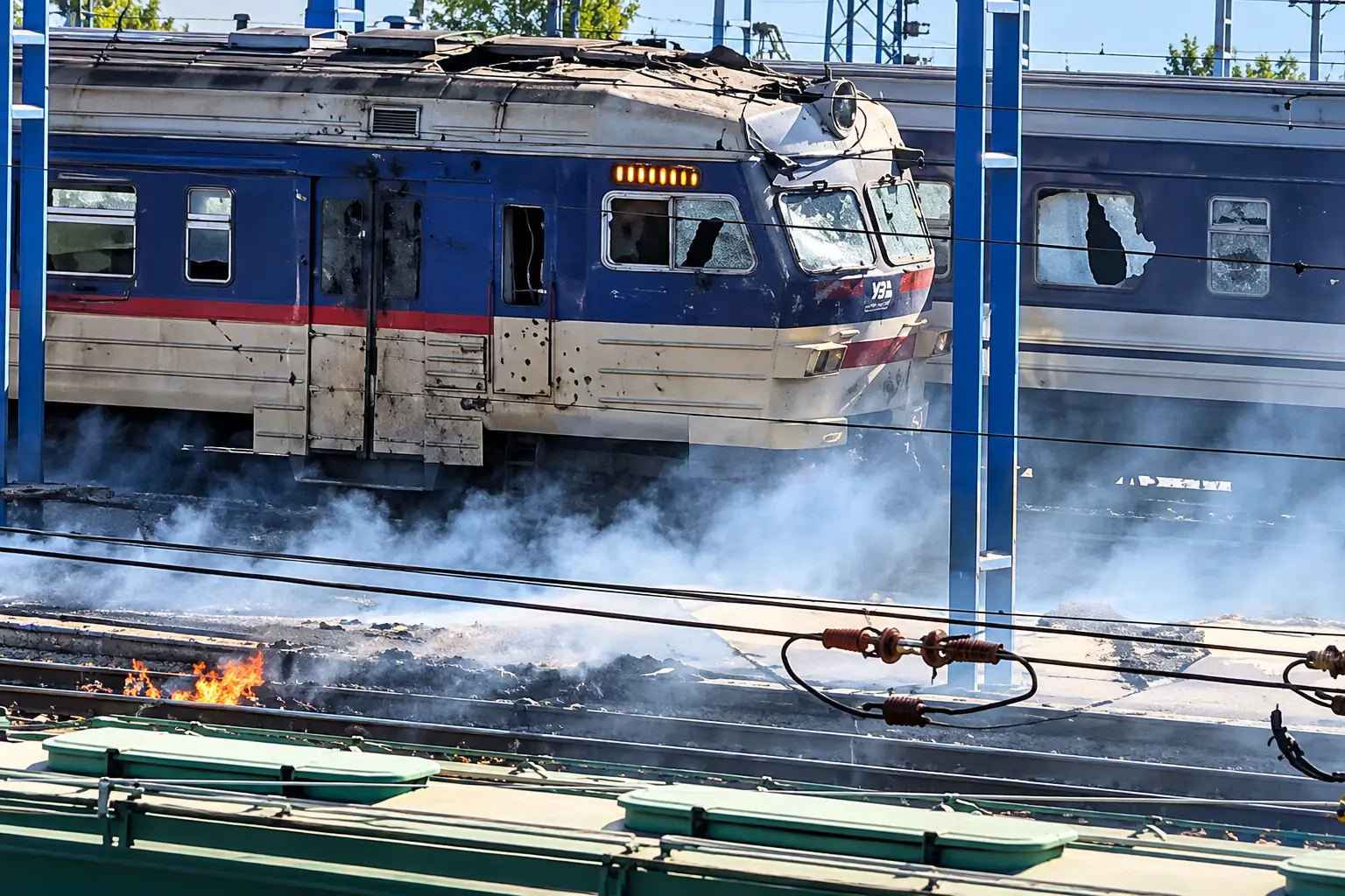 One of the damaged passenger trains emitting smoke following the reported Russian drone strike at a railway station in central Ukraine.